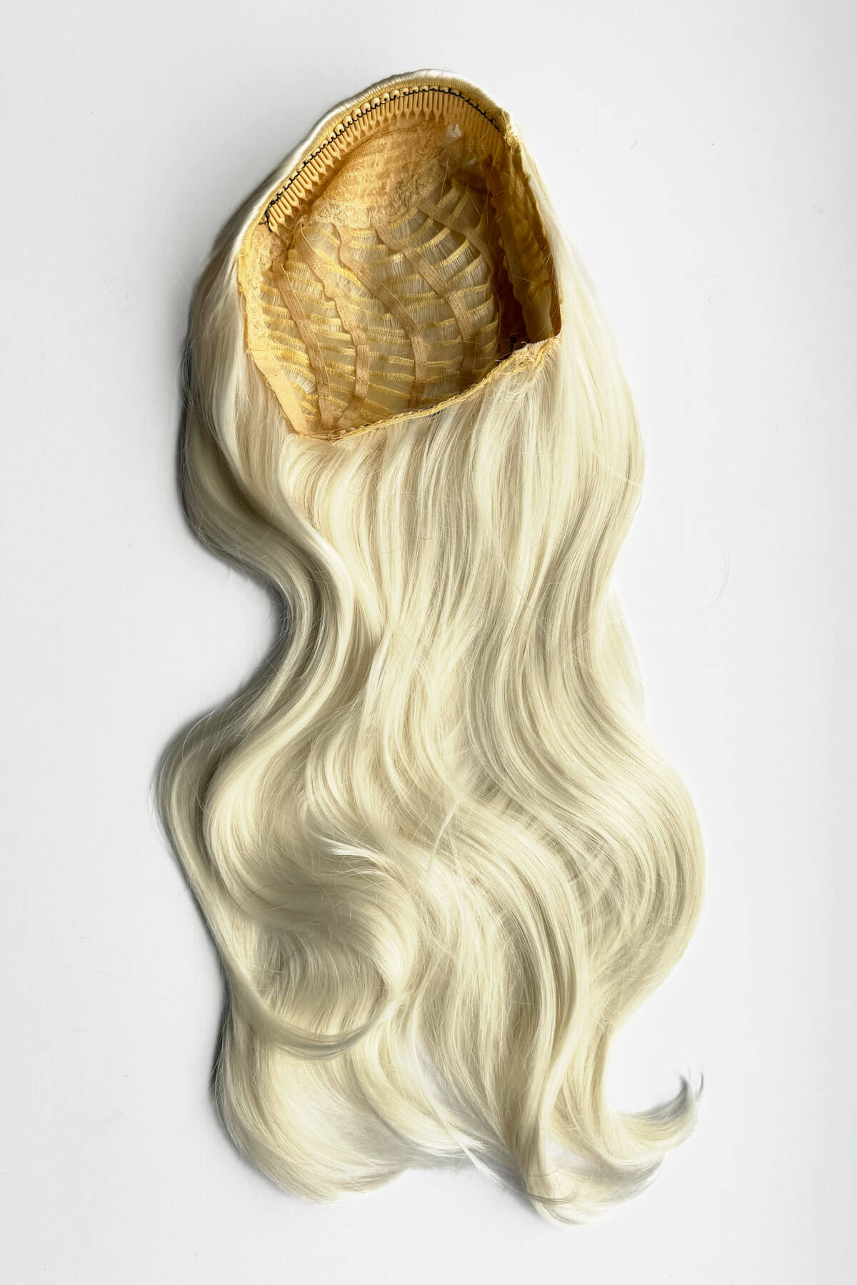 Blonde hair extension on a white background. Heat styleable half wig hairpiece, long wavy, Flexihair: Antoinette platinum 1001