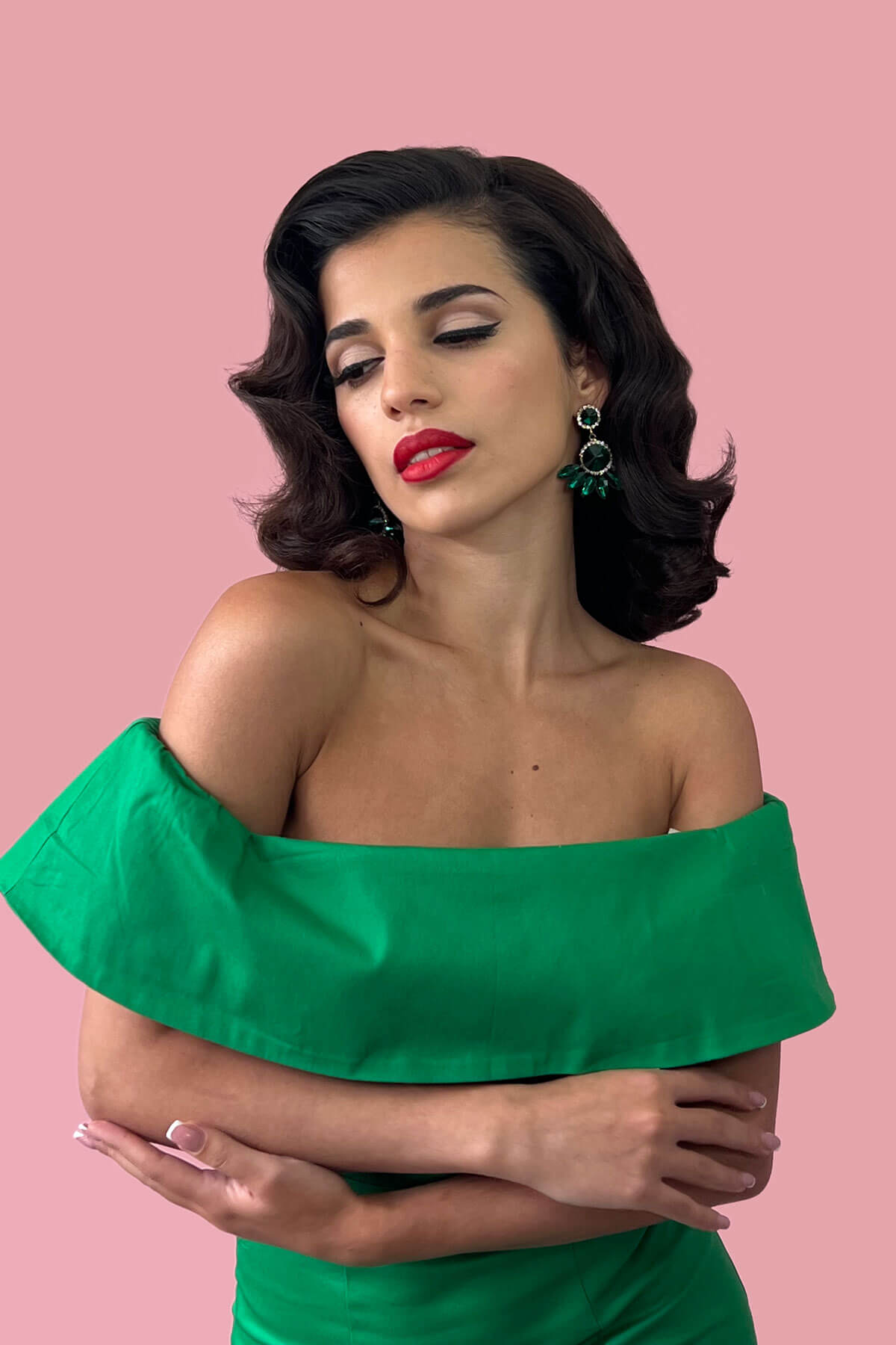Woman with gorgeous vintage wave hair wearing a green off-shoulder dress against a pink background. 1940s style half wig hairpiece with beautiful marcel waves: Virginia dark brown 4