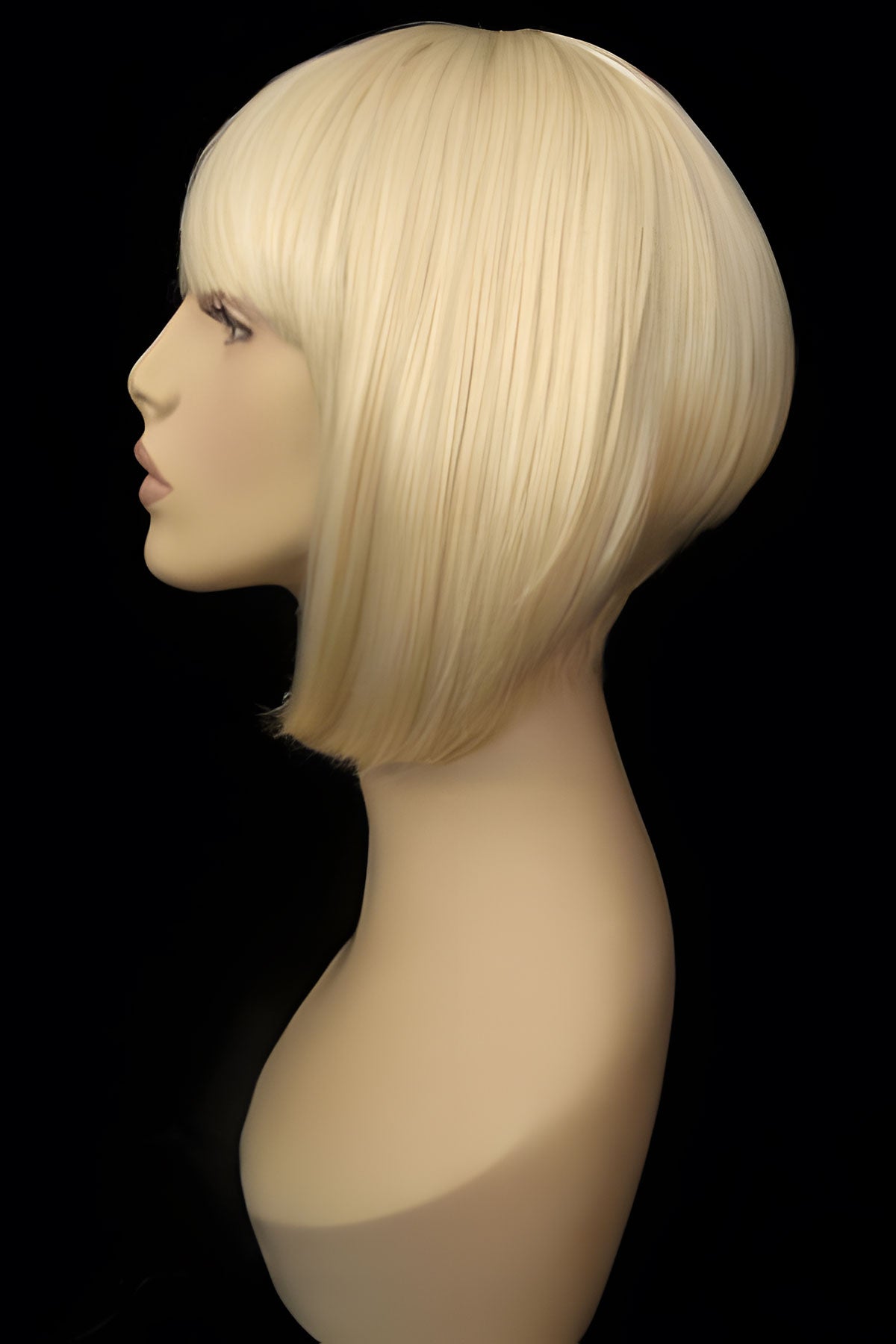 Blonde bob wig on a mannequin head against a black background. Blonde inverted bob wig: Rhiannon champagne blonde 613