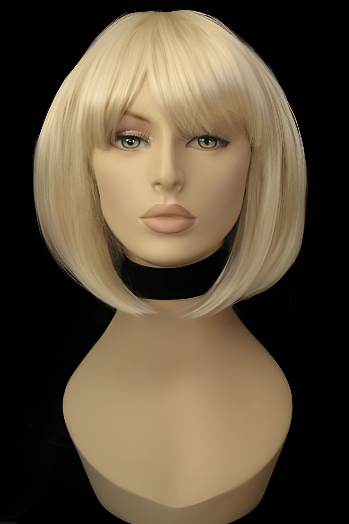 Blonde wig on a mannequin head against a black background. Blonde inverted bob wig: Rhiannon champagne blonde 613