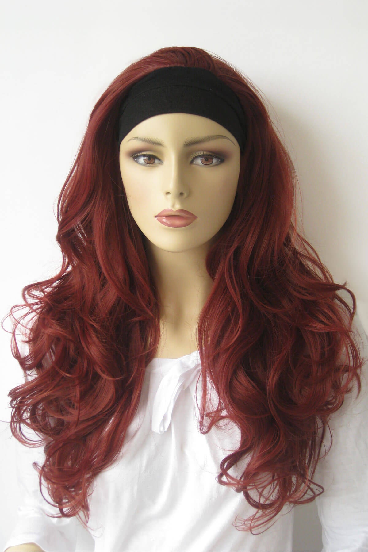Mannequin head with red wig and black headband on a white background. Red half wig hairpiece (3/4 wig), big loose curls: Verity copper red and wine red 350-39