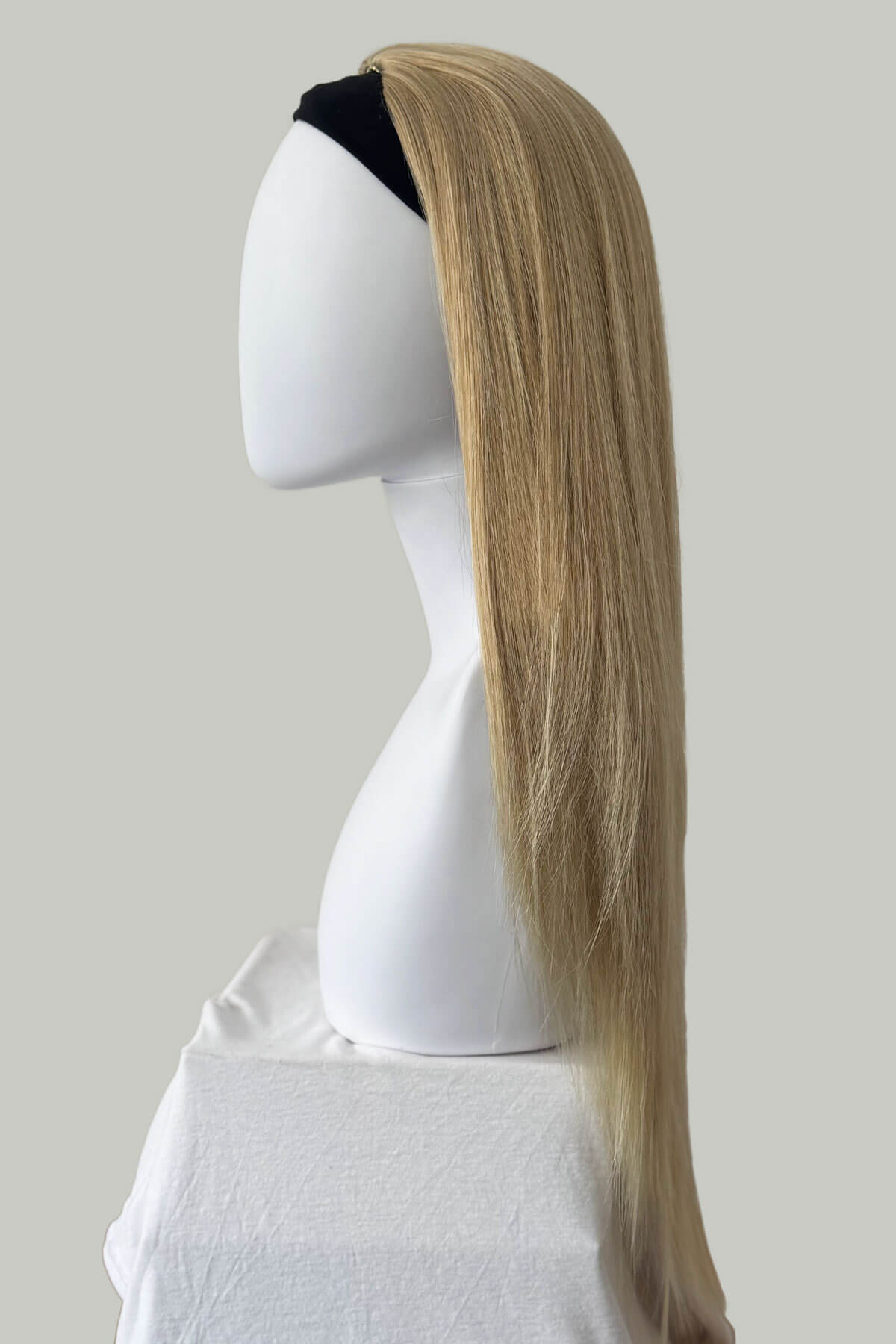 Blonde hair extension on a mannequin head against a plain background. Straight blonde half wig hairpiece (3/4 wig): Tabitha blonde 613T24