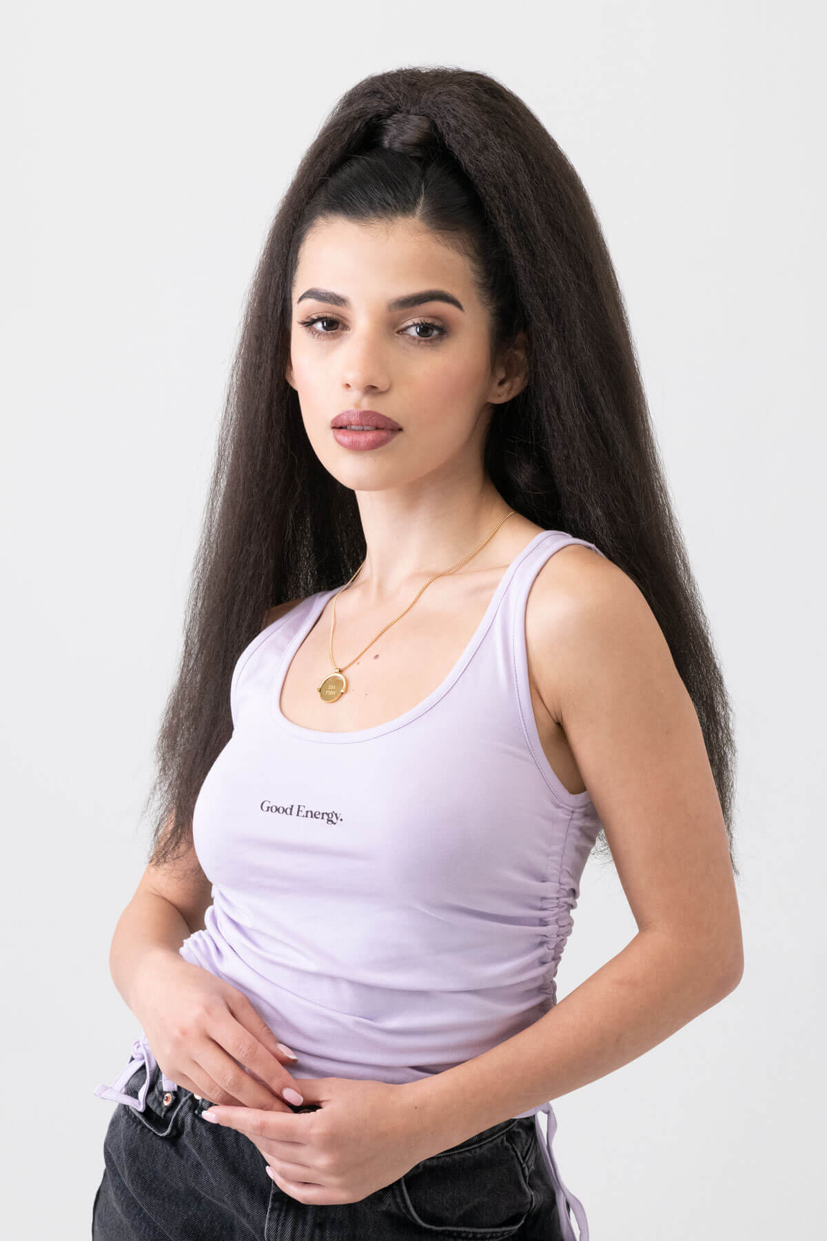 Woman wearing a light purple tank top with text on a plain background. Long Yaki perm ponytail extension with tight kinks and waves: Indi dark brown 4