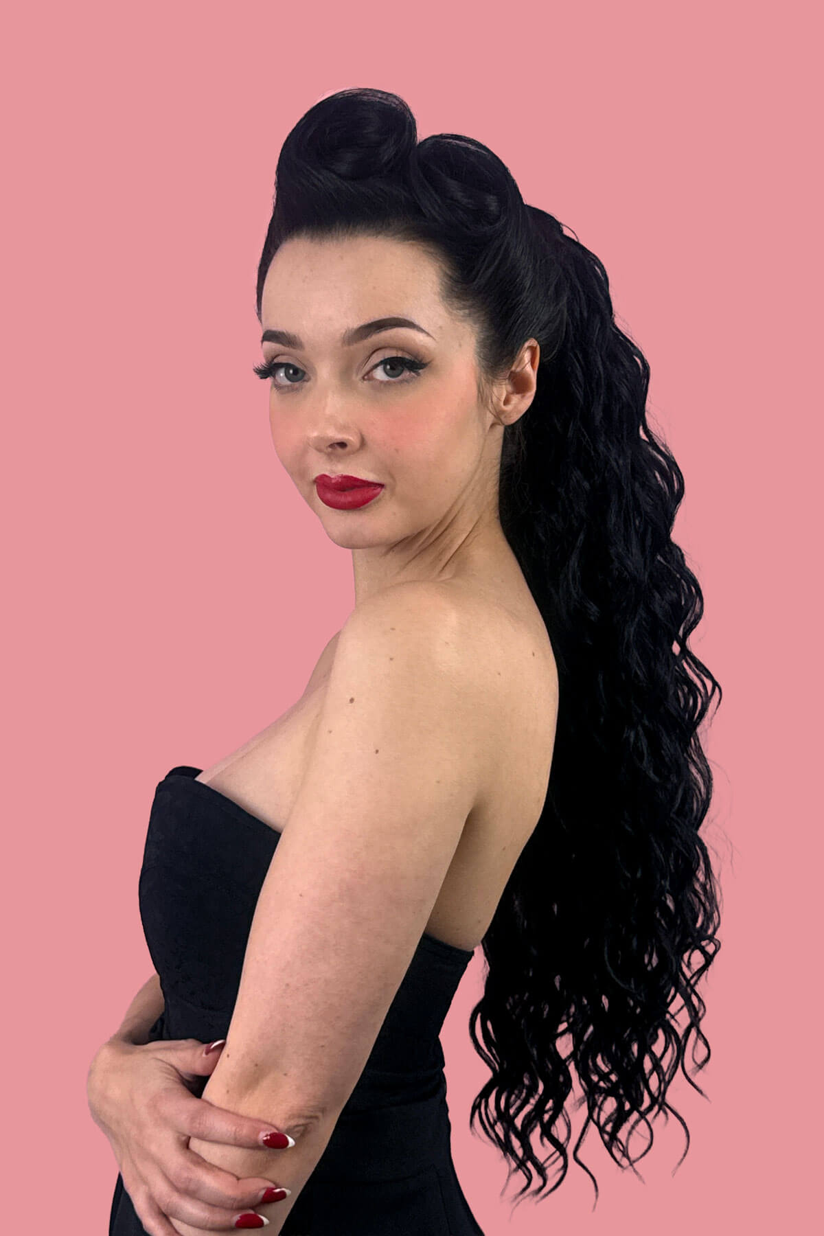 A woman in profile wearing a black strapless dress, showcasing a long, dark, curly wavy hair extension against a solid pink background. Long Curly Ponytail Hair Piece Extension