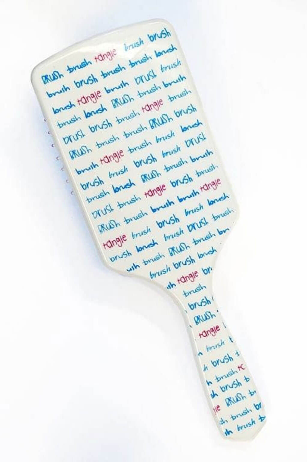 White paddle brush with text on a white background. Brush Brush Tangle' Wide Toothed Professional Hair Brush