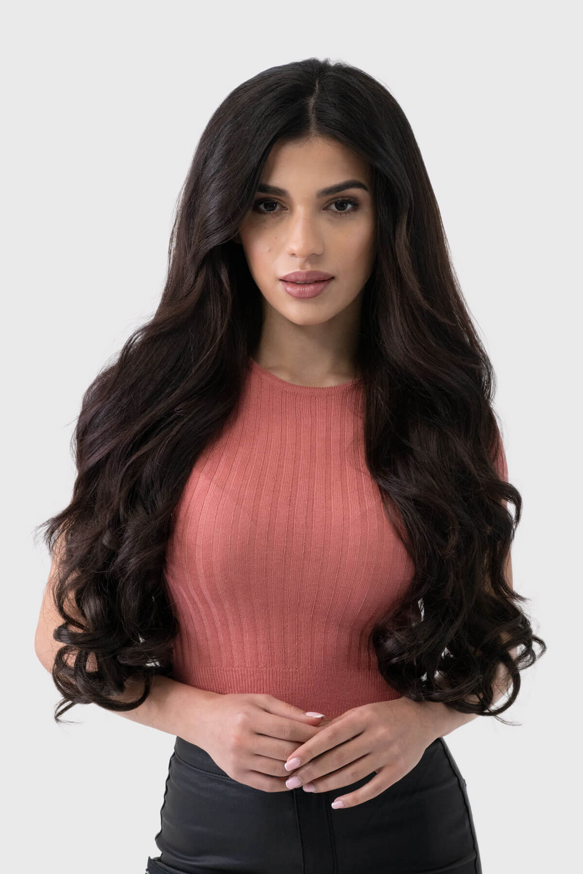 Woman with long, wavy hair wearing a pink top against a white background. synthetic hair extension set, 5 piece, 22 inches long, 300g
