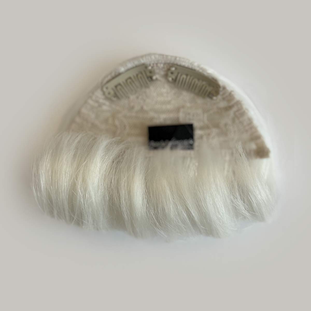 Blonde hair extension on a white background. Victory roll fringe/bangs hairpiece, 1950s vintage style: Rosa platinum 1001