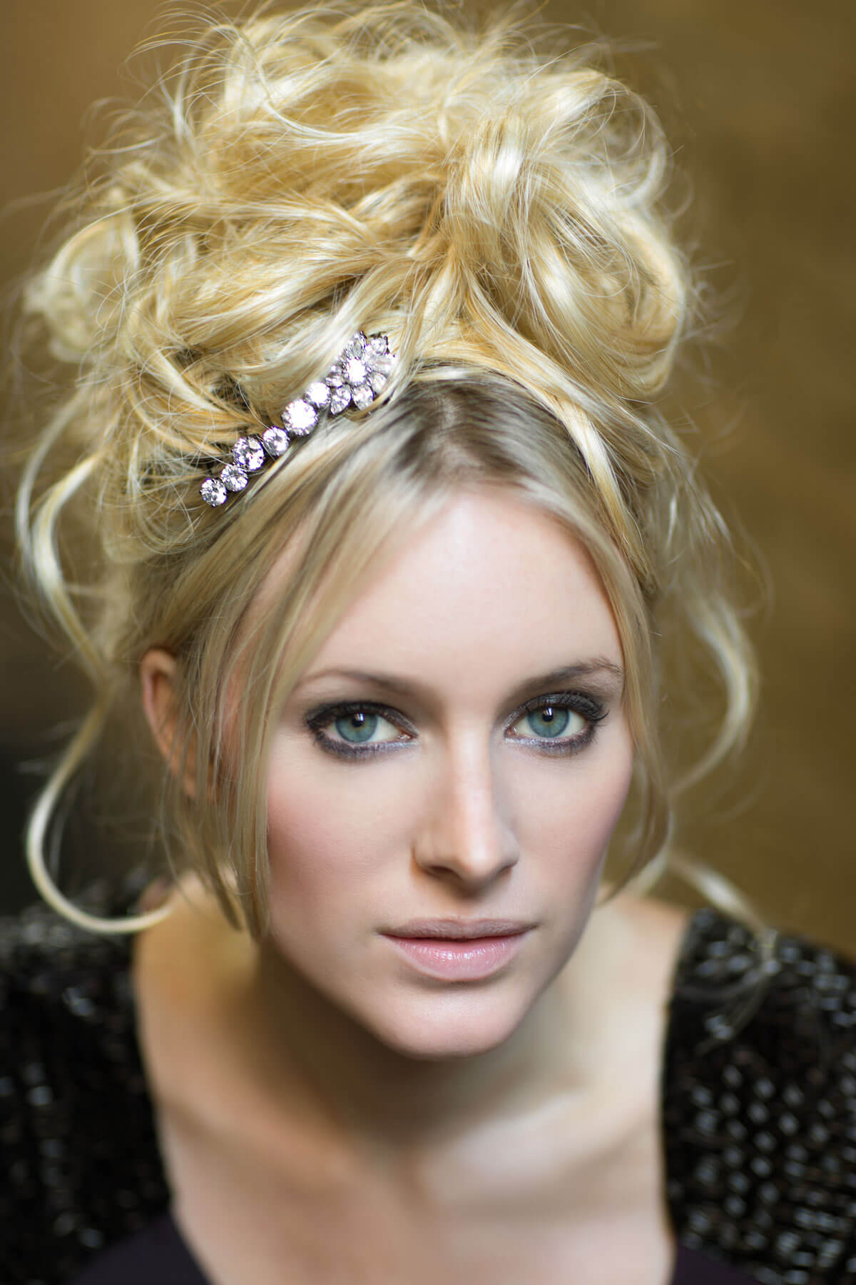 Woman with blonde hair styled in an updo with a decorative headband against a neutral background. Extension hairpiece, long, versatile, Flexihair: Cristina wheatfield blonde 24H613
