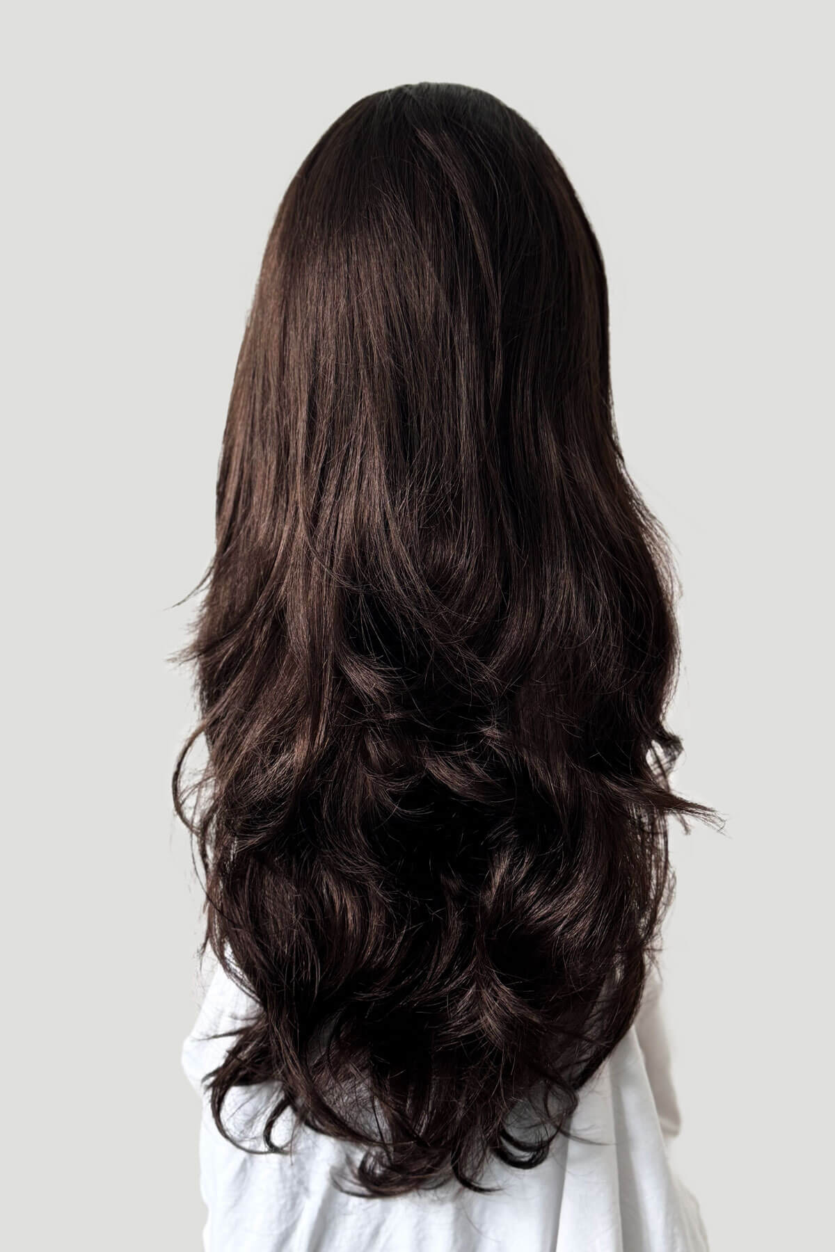 Long, dark brown hair extension on a plain background. Brown half wig hairpiece, full, long with gentle waves: Taya dark chocolate brown 6