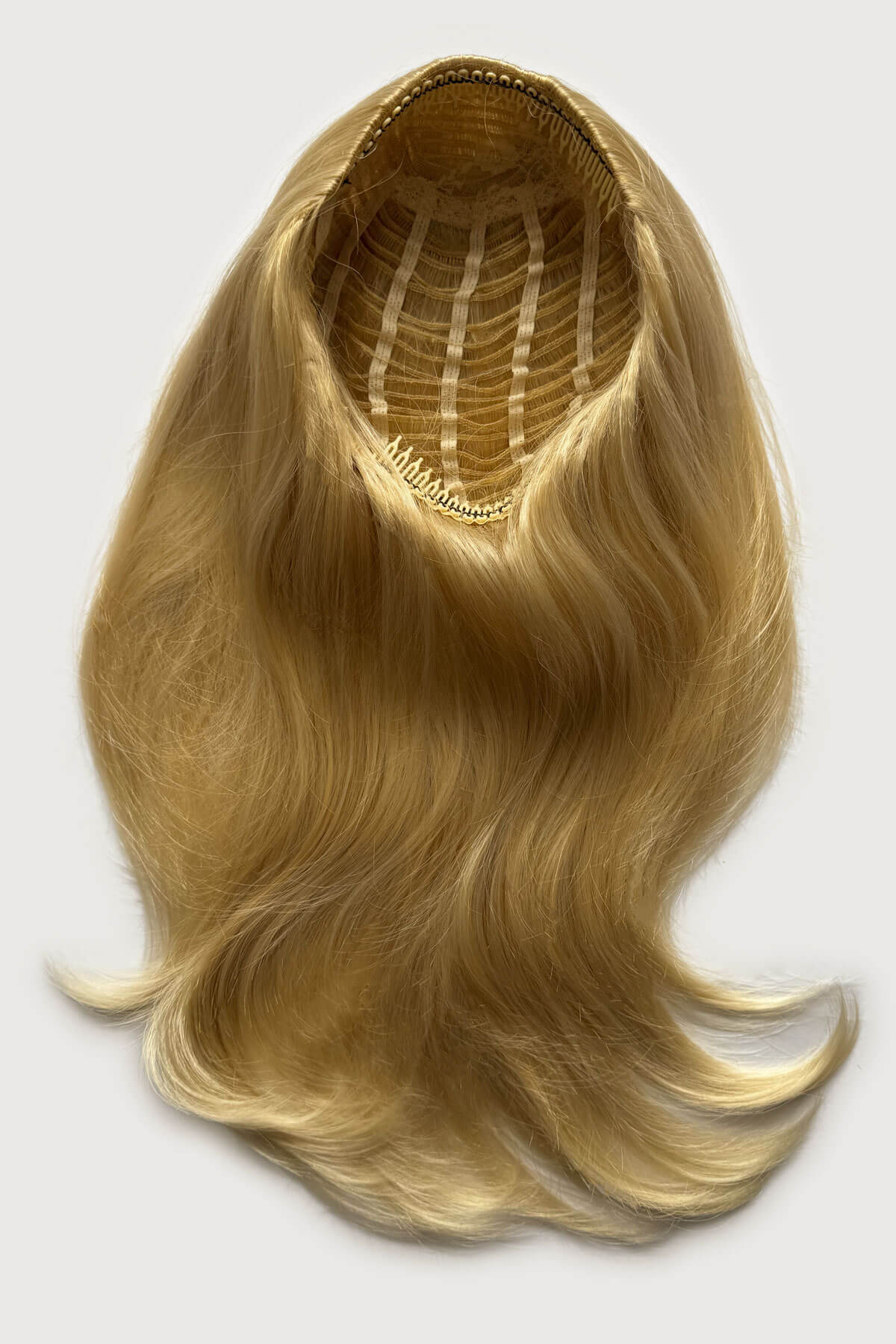 Blonde hair extension on a white background. Straight blonde half wig hairpiece (3/4 wig), layered: Autumn light ash blonde 24BT613