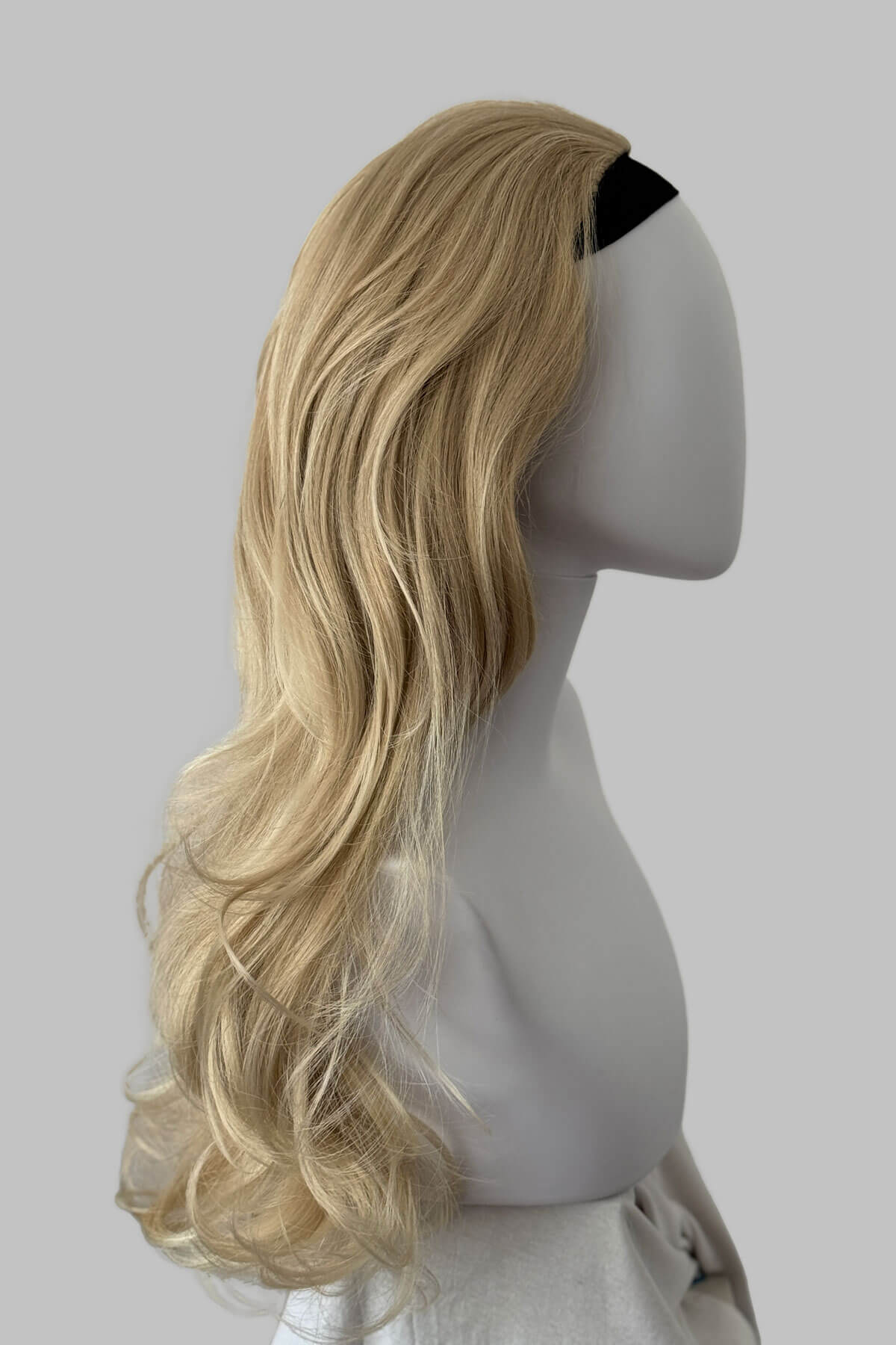 Blonde wig on a mannequin head against a plain background.Long blonde 3/4 hairpiece (half wig), big loose curls: Zara blonde 613T24