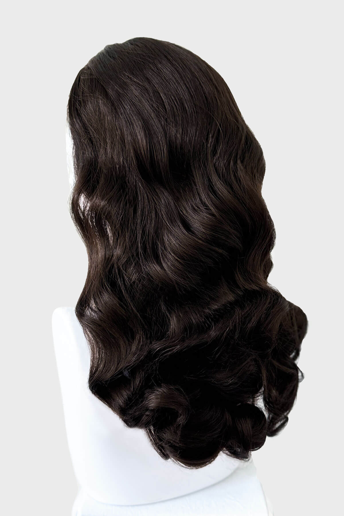 Dark brown wig on a mannequin head against a white background. 1950s style half wig hairpiece with beautiful waves: Morgana dark brown 6