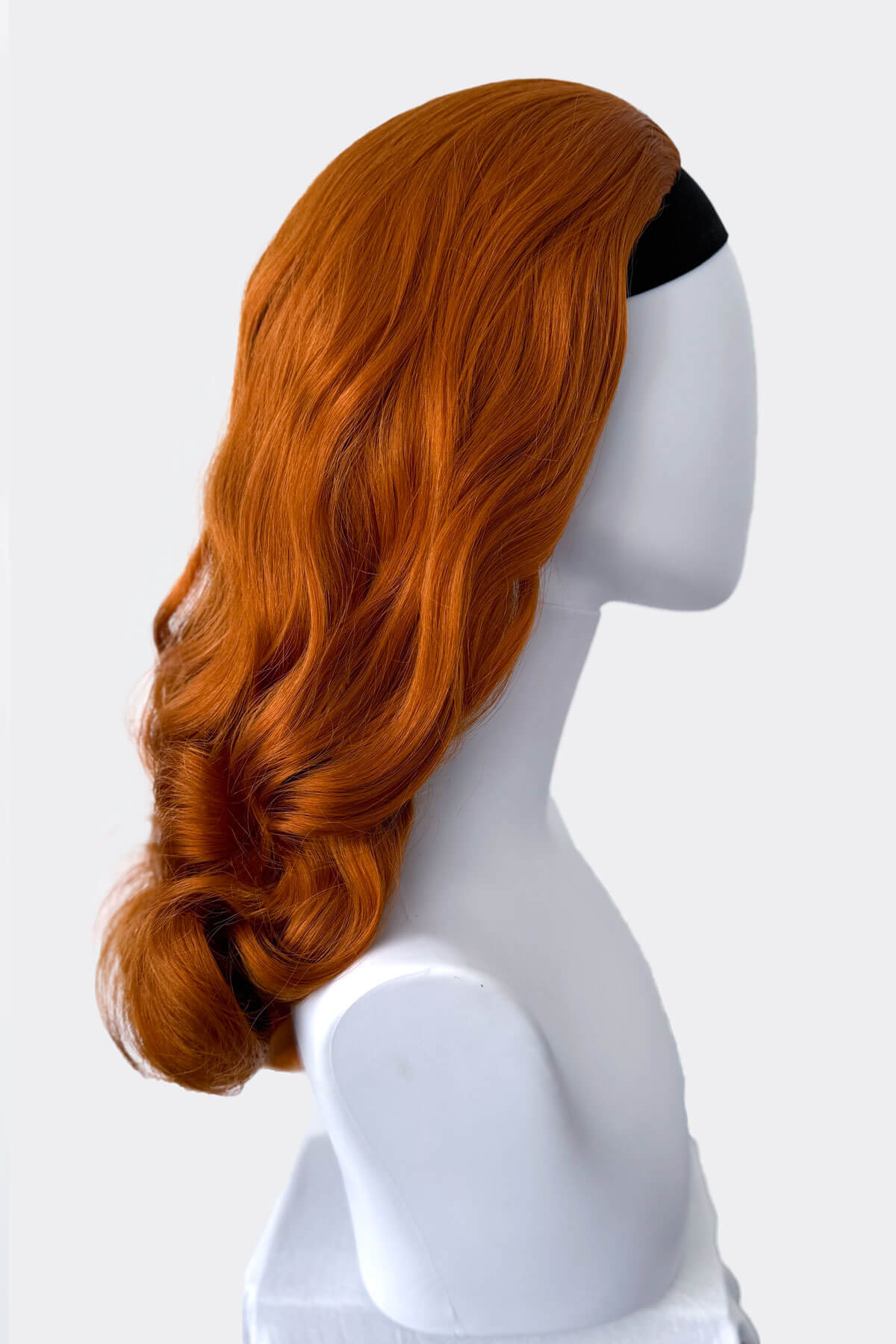 Ginger red wig on a white mannequin head with a white background. 1950s style half wig hairpiece with beautiful waves: Morgana ginger