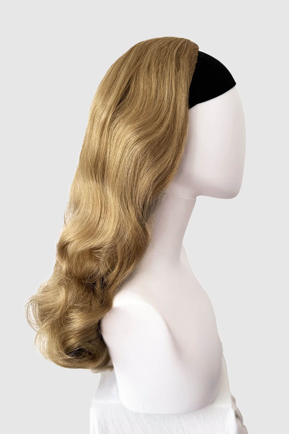 Blonde wig on a mannequin head against a white background. 1950s style half wig hairpiece with beautiful waves: Morgana blonde 24H613
