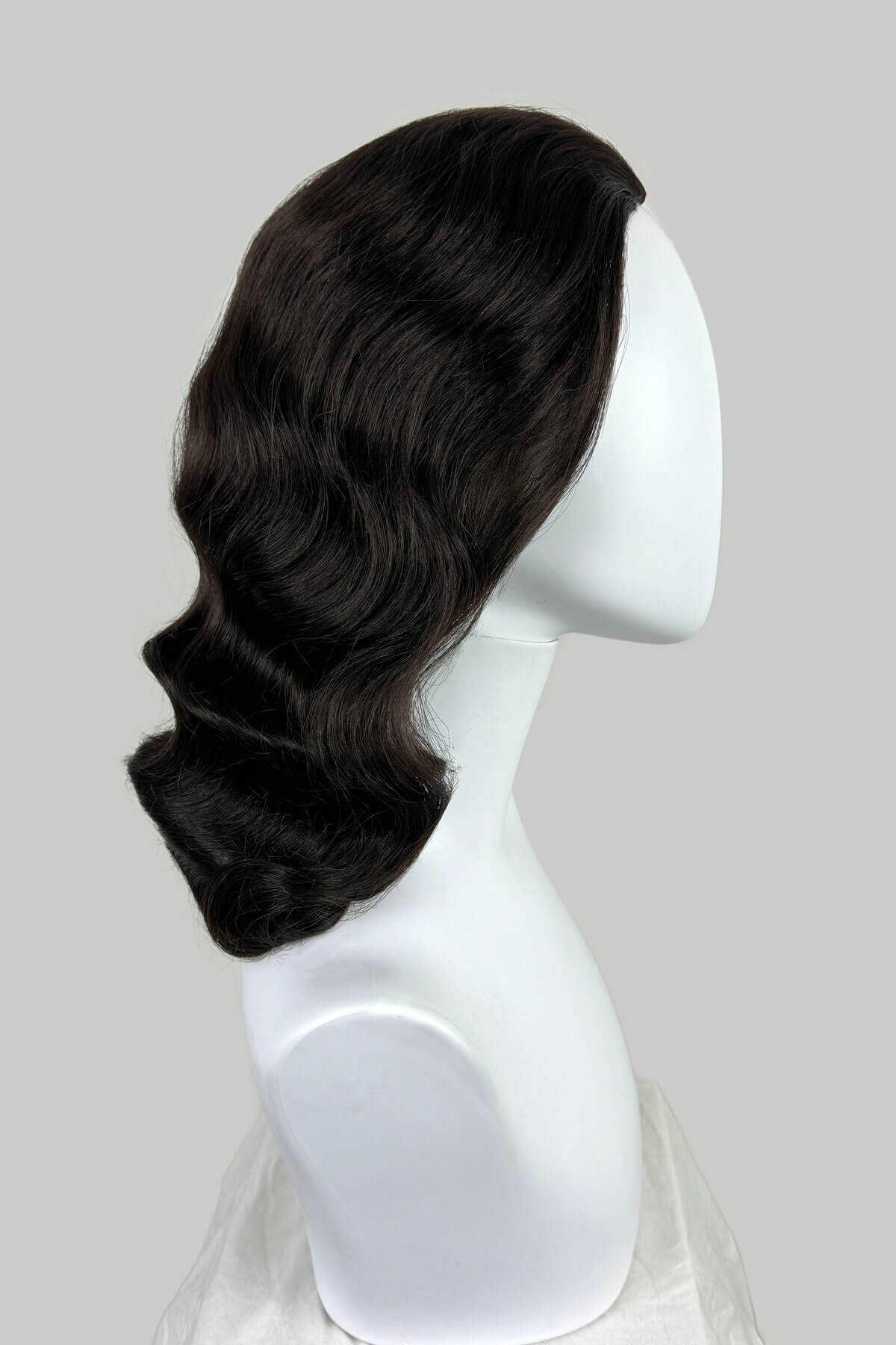 Black wig on a white mannequin head against a gray background. 1950s style half wig hairpiece with deep finger waves: Deborah Dark brown 4