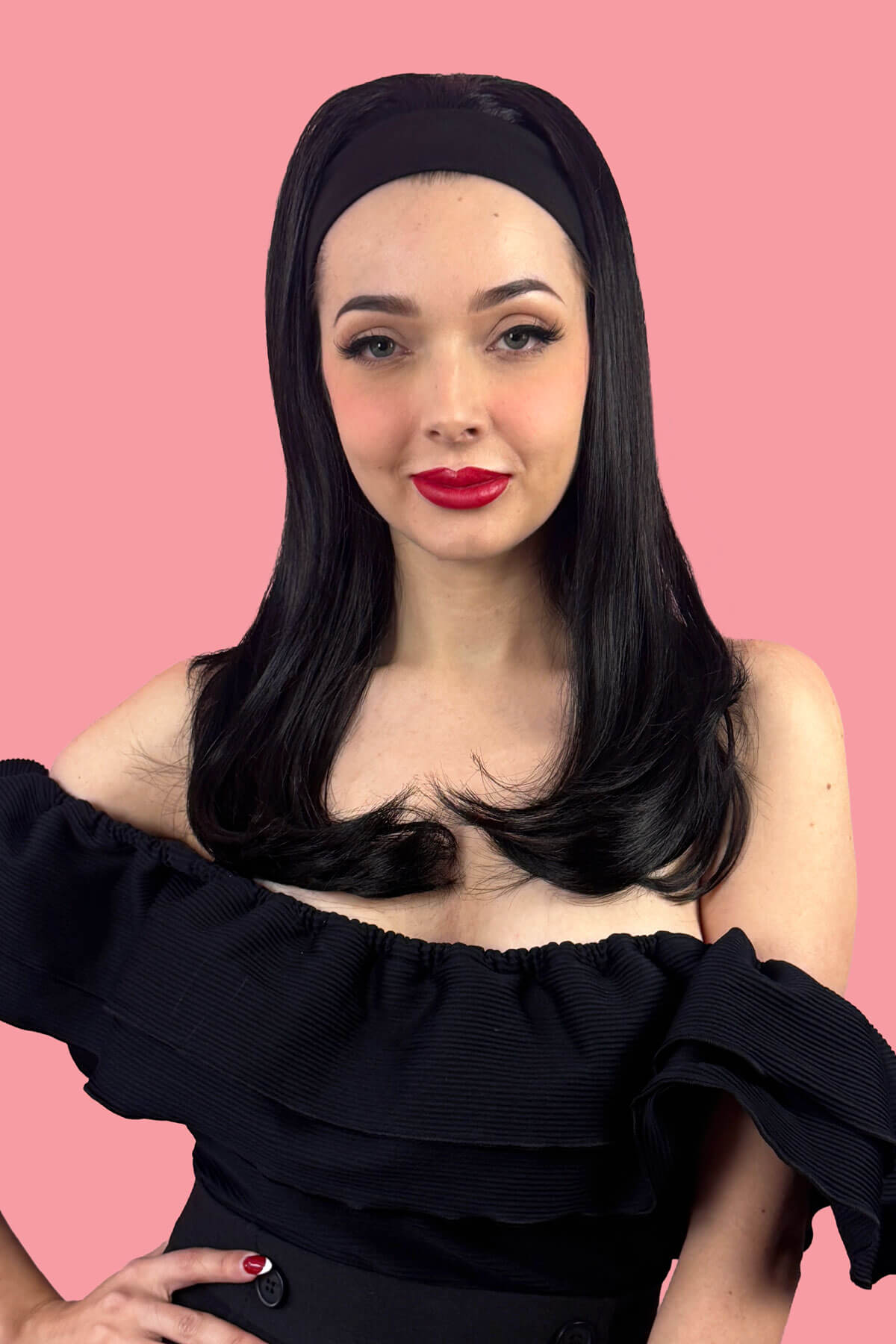 Woman with long black hair with a headband in it wearing a black off-shoulder top against a pink background. Headband half wig hairpiece, long and straight: Isla black 1B