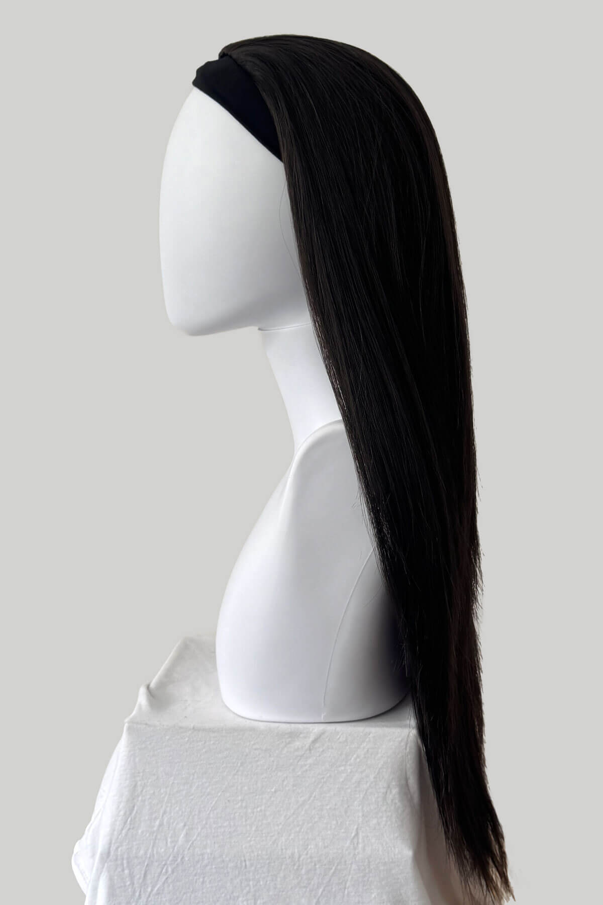 Dark brown hair extension on a white mannequin head against a light gray background. Straight brown half wig hairpiece extension, long: Faye dark brown 4