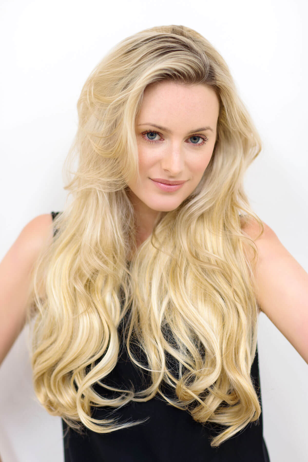 Woman with long, wavy blonde hair against a white background. Heat styleable half wig hairpiece (3/4 wig), long wavy, Flexihair: Kate dark blonde 24BH613