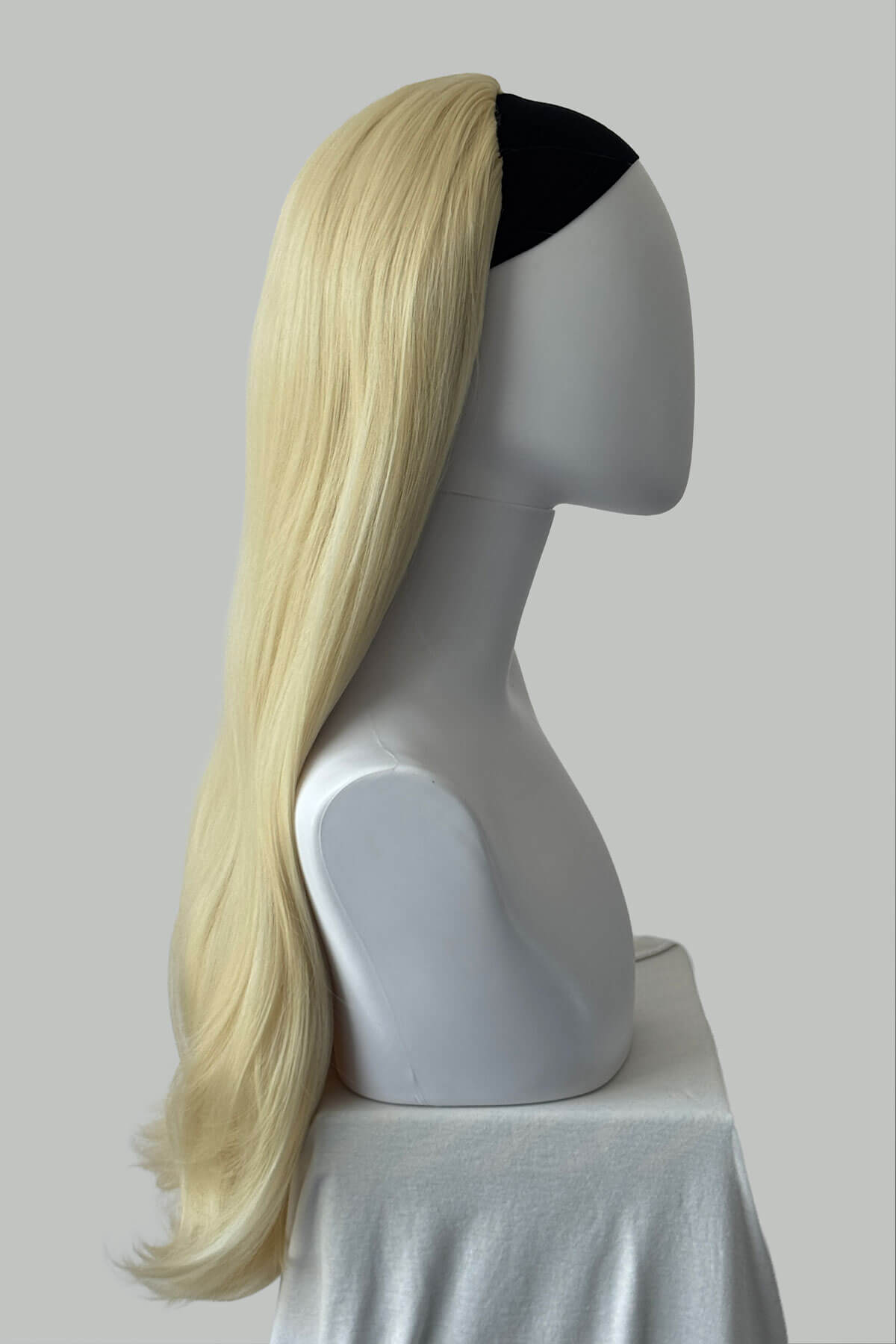 Blonde wig on a mannequin head with a black band against a plain background. Kate - Heat Styleable Extra Long, Gentle Wave Half Wig blonde 613