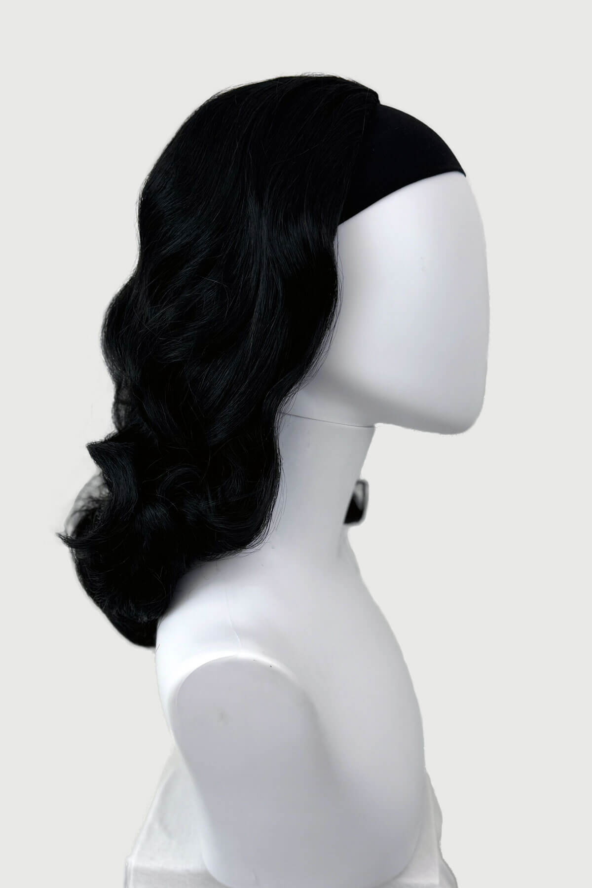 Black wig on a mannequin head against a white background. 1950s style shoulder length half wig hairpiece with beautiful vintage waves: Onyx colour jet black 1