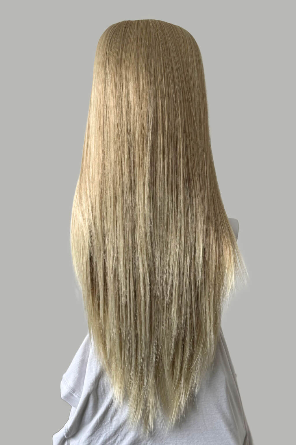 Blonde wig on a mannequin head against a gray background. 1960s style hair, high crown long straight half wig: Andrea blonde 613T24
