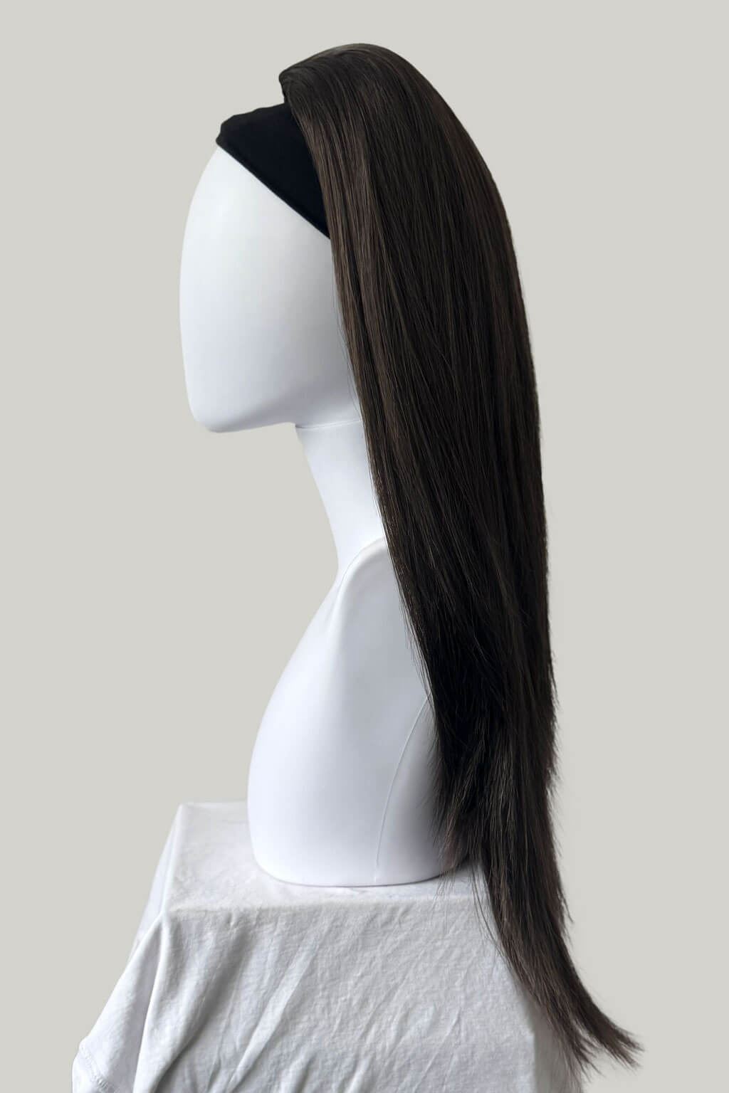 Chestnut brown hair extension on a mannequin head against a plain background. 1960s style hair, high crown long straight half wig: Andrea chestnut brown 8