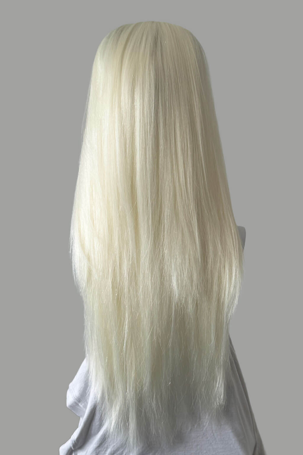 Long blonde wig on a gray background. 1960s style hair, high crown long straight half wig: Andrea platinum blonde 1001