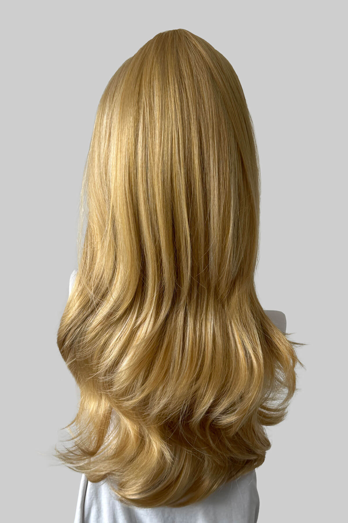A long wavy blonde half wig, displayed on a mannequin against a light grey background. Claudia - Volume Boosting Long Gentle Bouncy Layered Half wig honey blonde 24BH613