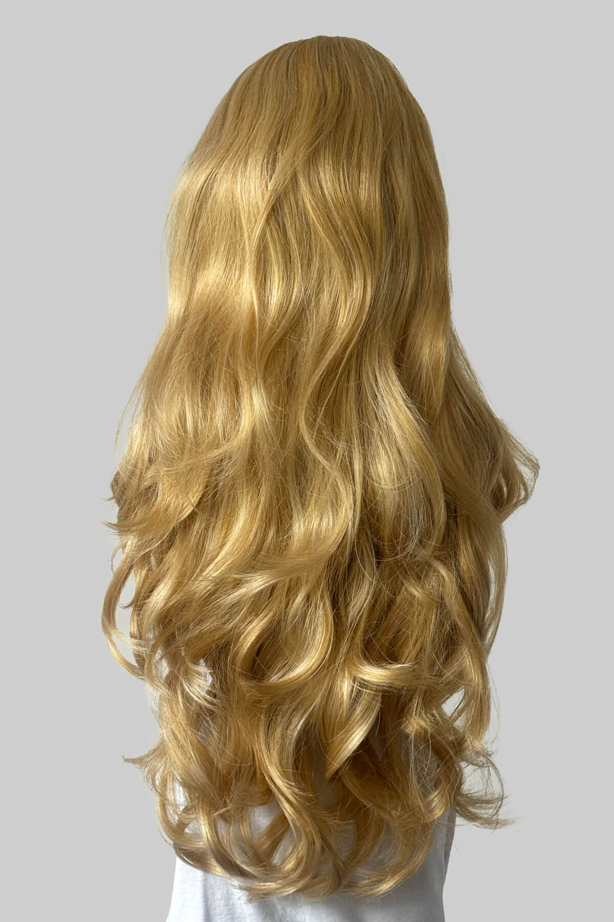 Long, wavy blonde wig shown from the back on a mannequin against a plain light grey background. Corrine - Bouncy Blowout style with Volume Booster Half Wig warm blonde 24BH613