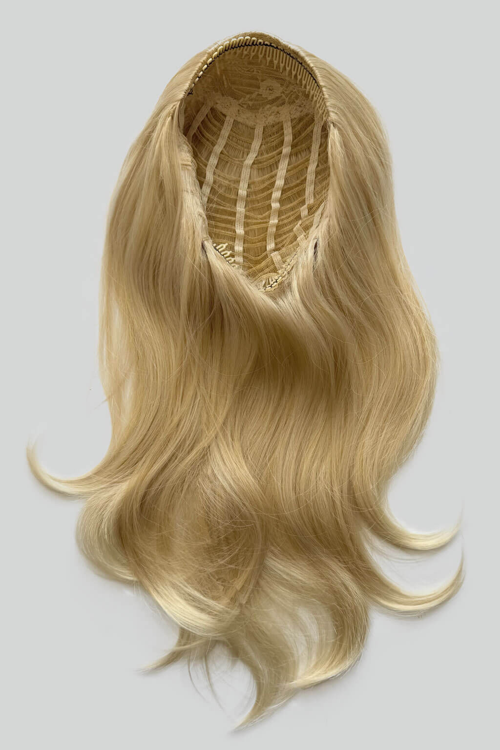 Blonde hair extension on a gray background. 1960s style hair, high crown long straight and layered half wig: Juliette blonde 24BT613