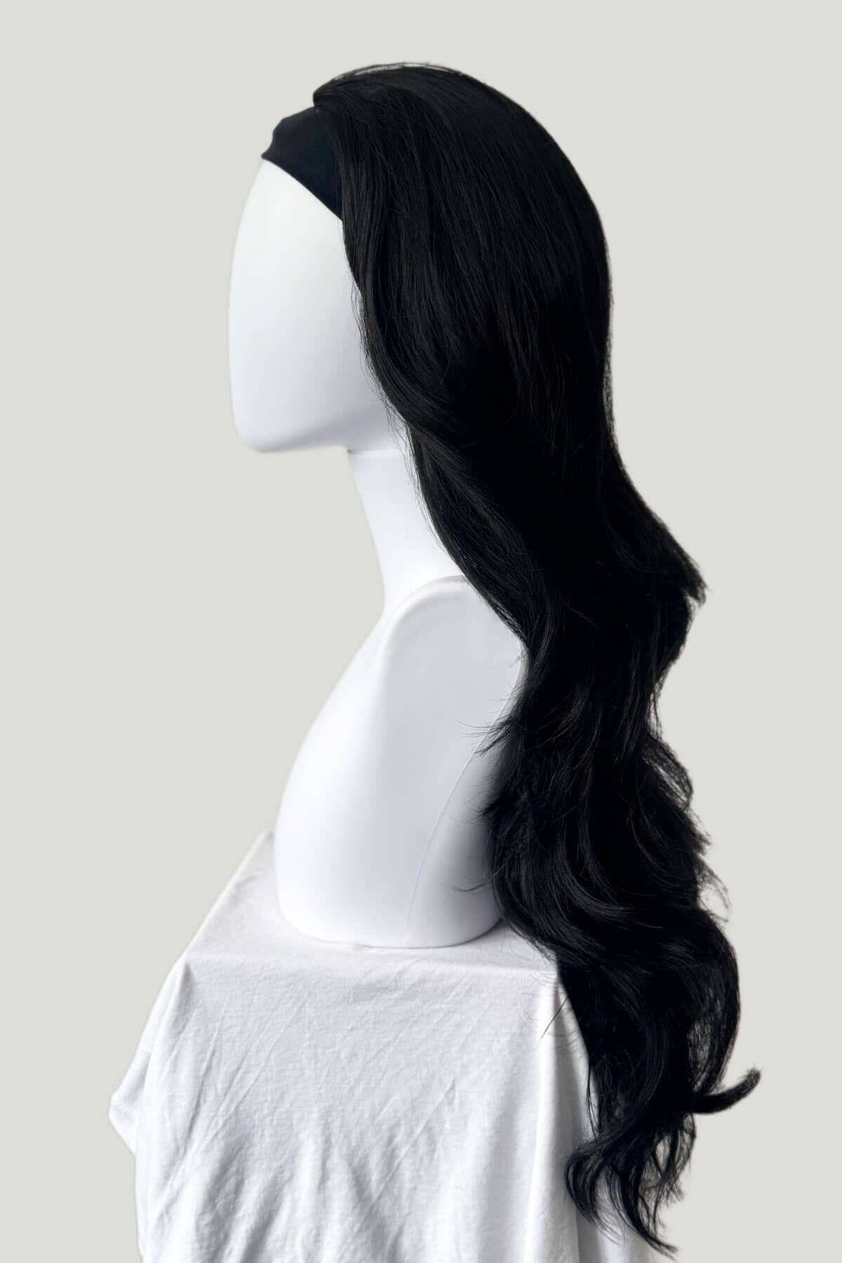 Black wig on a mannequin head against a plain background. Black 3/4 hairpiece (half wig) with long waves: Jessie black 1b