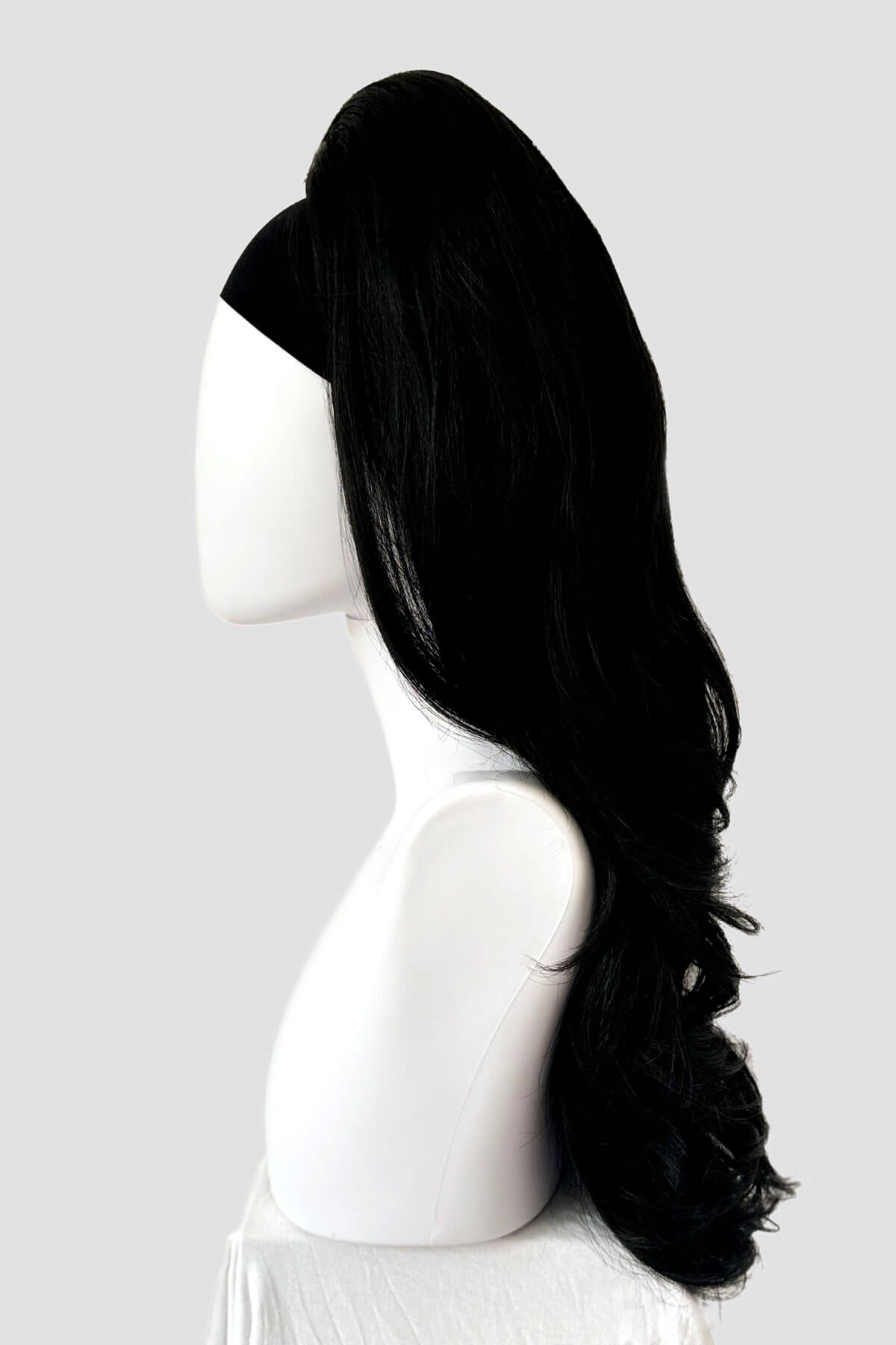 Black wig on a mannequin head against a white background. High crown long, wavy half wig and volume ring: Bardot black 1B