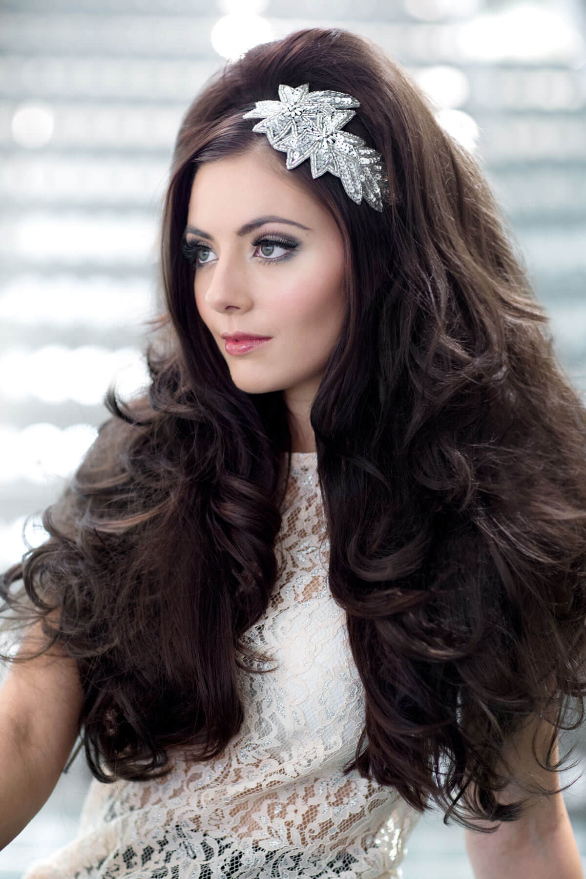 Woman with long, wavy hair wearing a decorative headband against a blurred background. Volume boosting 3/4 hairpiece, long, wavy, heat styeable: Gisele chestnut brown 8