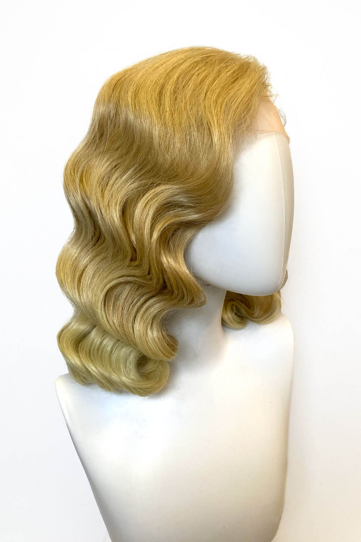 Blonde wig on a mannequin head against a white background. Blonde pinup wig, lace front: Irina