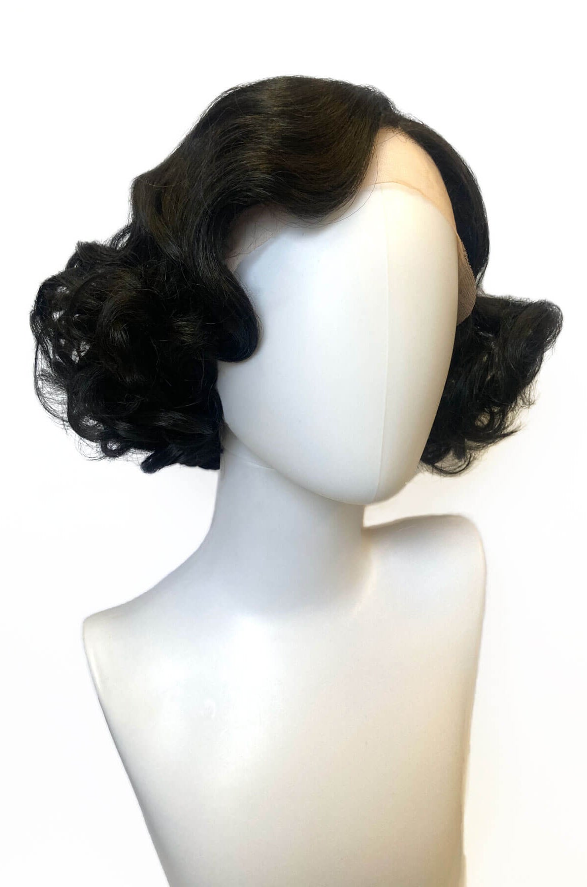 Black wig styled in curls on a mannequin head against a white background. Black pinup wig, lace front, vintage style: Halle