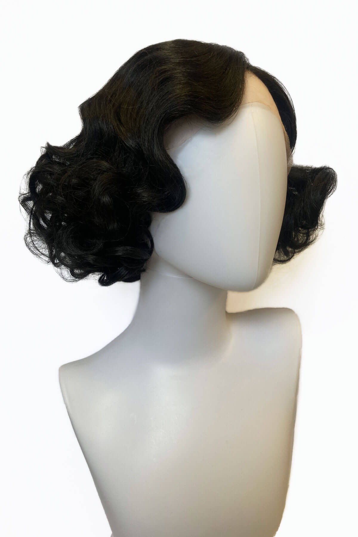 Black wig on a mannequin head against a white background. Black pinup wig, lace front, vintage style: Halle