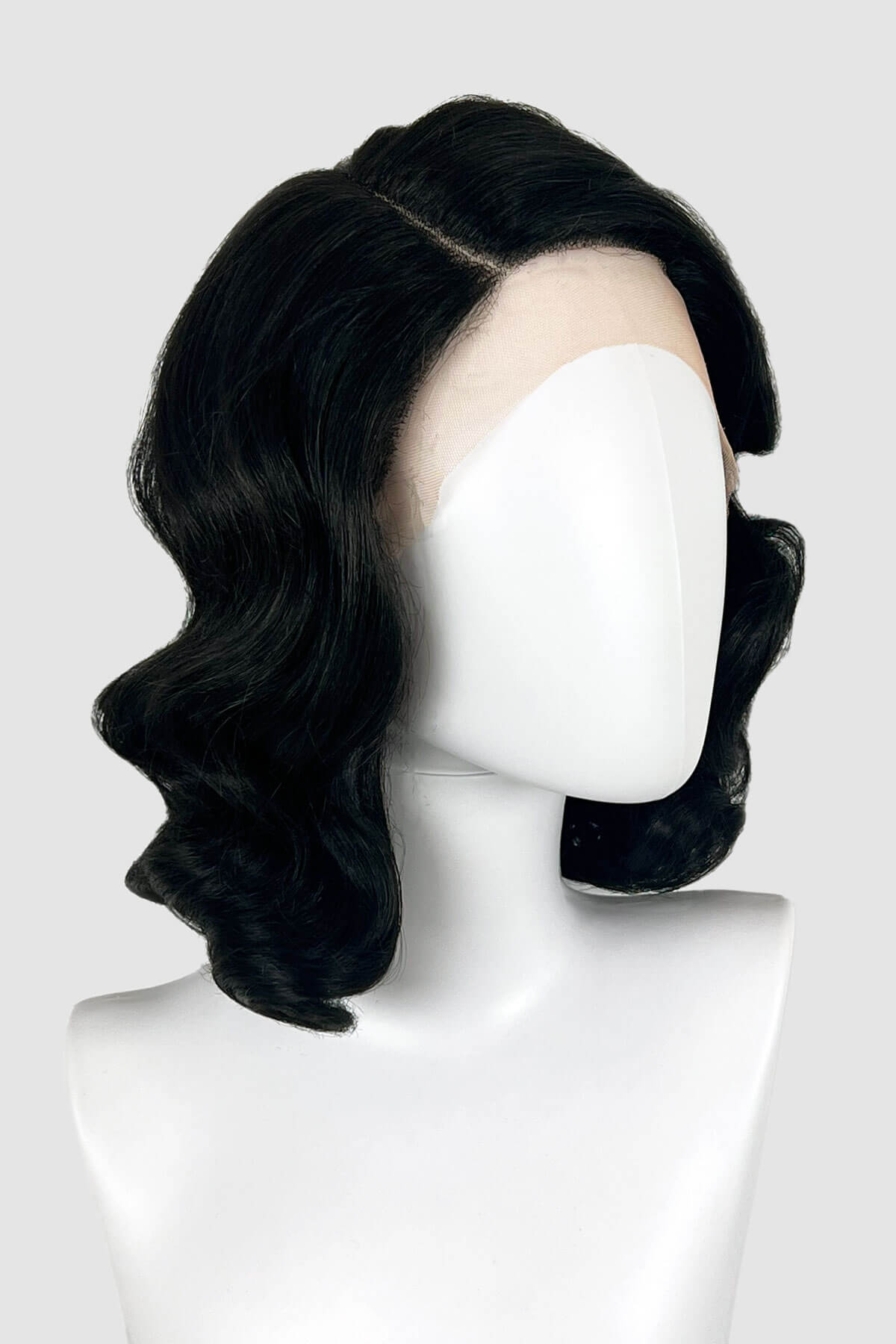 Black wig on a mannequin head against a white background. Black lacefront wig, pinup/vintage style, mid length with finger waves: Etta
