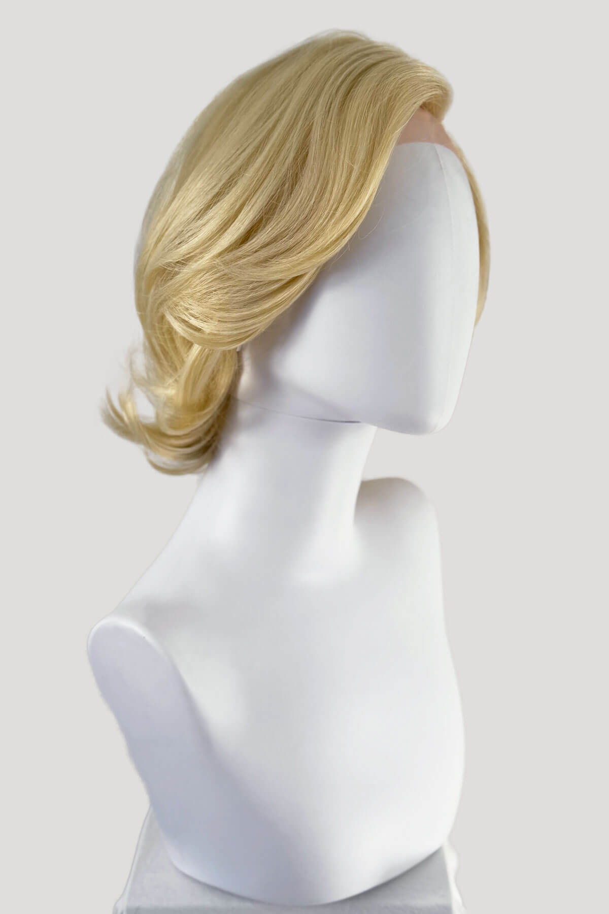 Blonde wig on a mannequin head against a white background. Blonde lacefront wig, pinup/vintage style, mid length, hollywood elegance: Norma Jeane