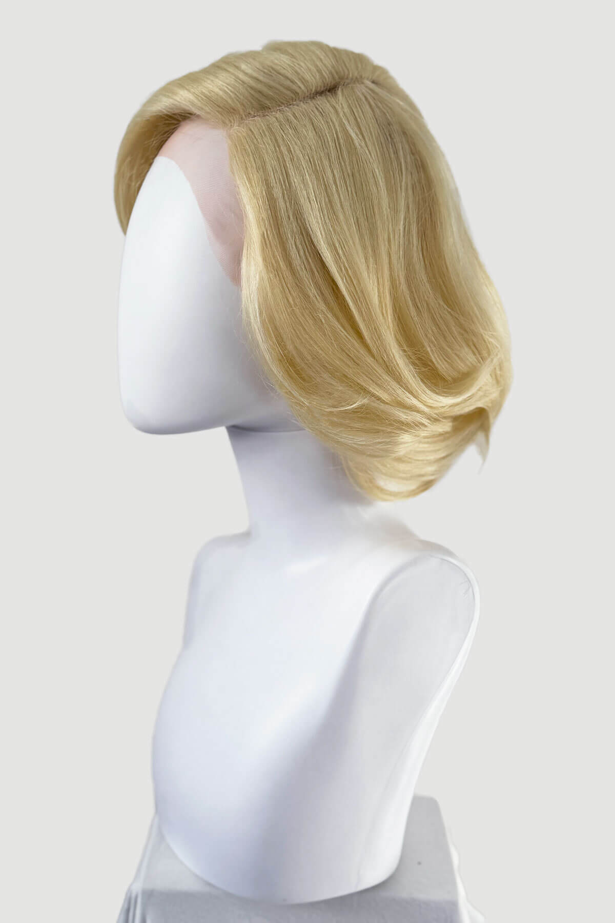Blonde wig on a mannequin head against a white background. Blonde lacefront wig, pinup/vintage style, mid length, hollywood elegance: Norma Jeane