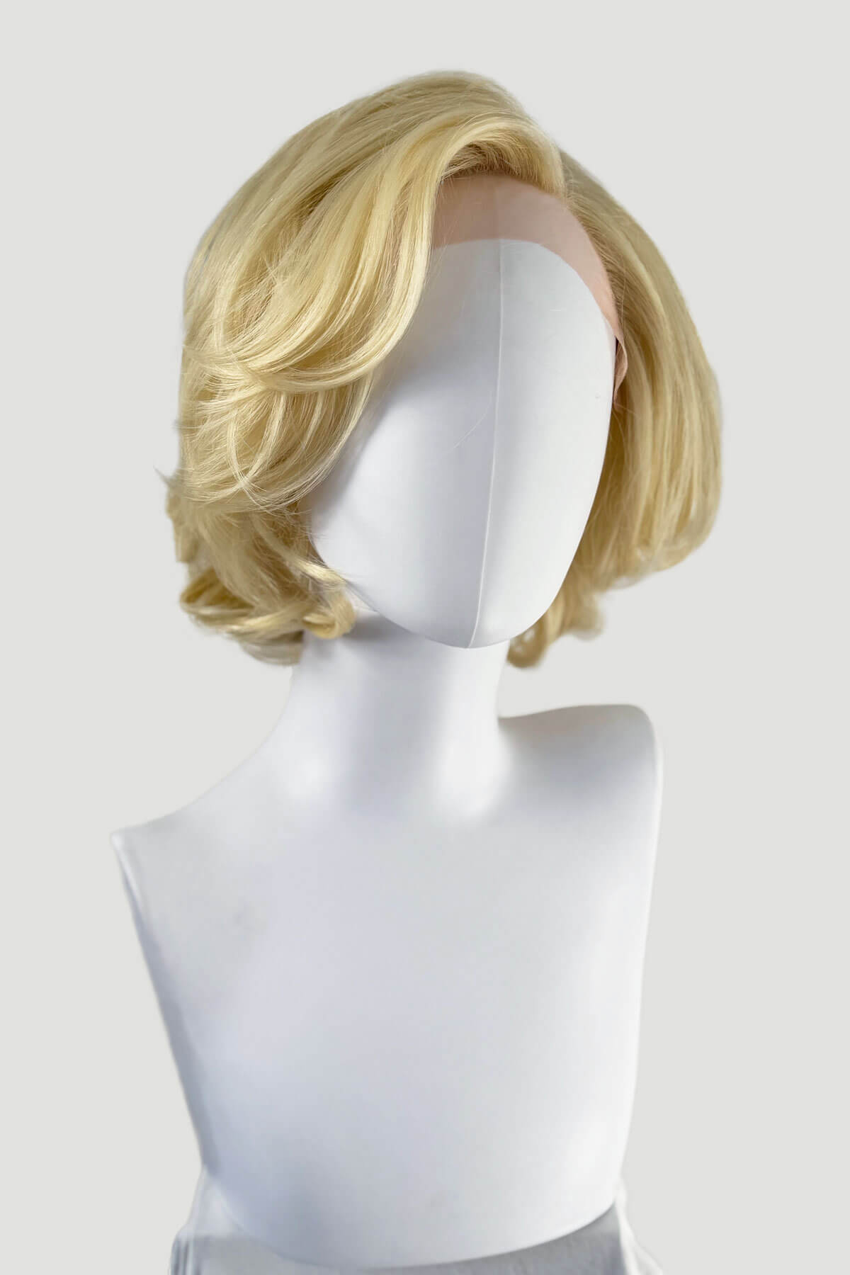 Blonde wig on a mannequin head against a white background. Blonde lacefront wig, pinup/vintage style, mid length, hollywood elegance: Norma Jeane