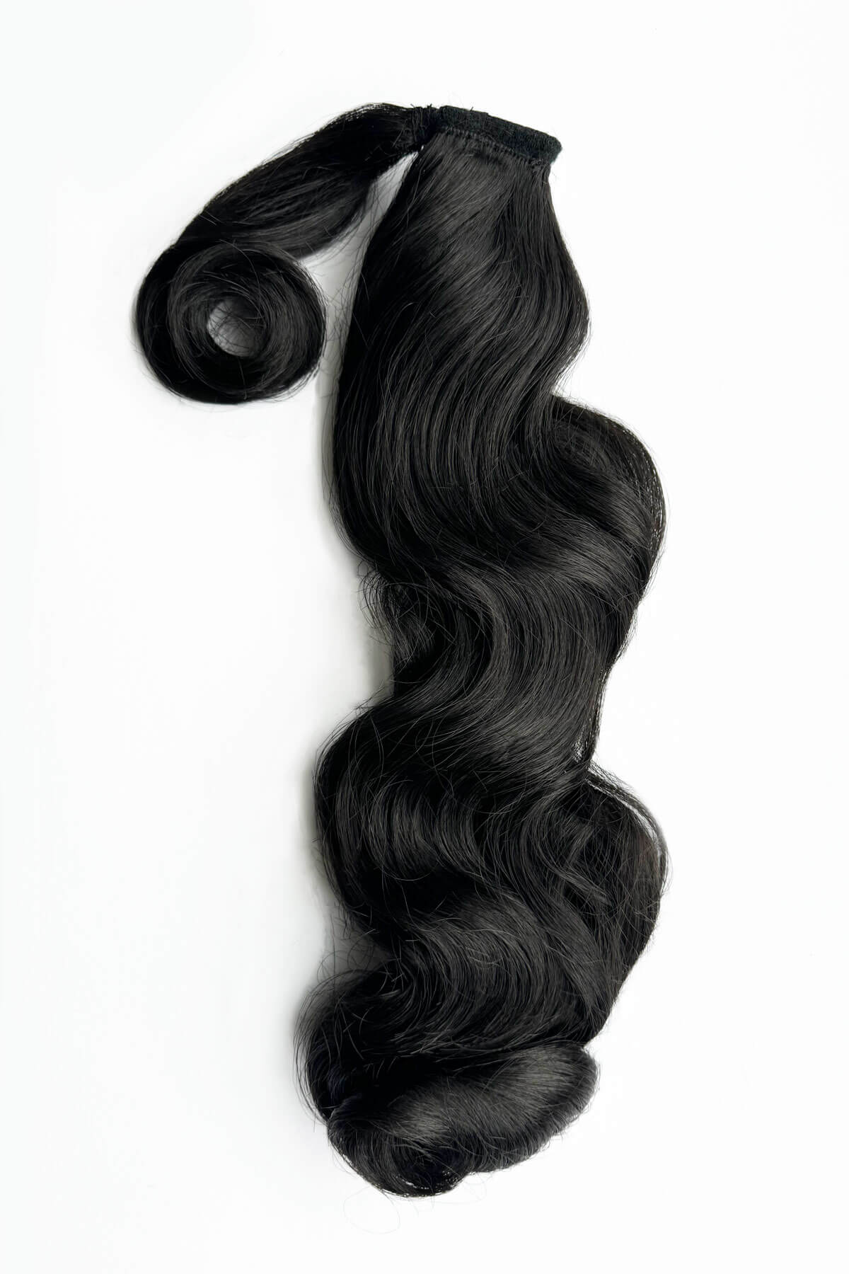Black hair extension with wavy texture on a white background. Retro style ponytail hairpiece, long with vintage waves: Arabella