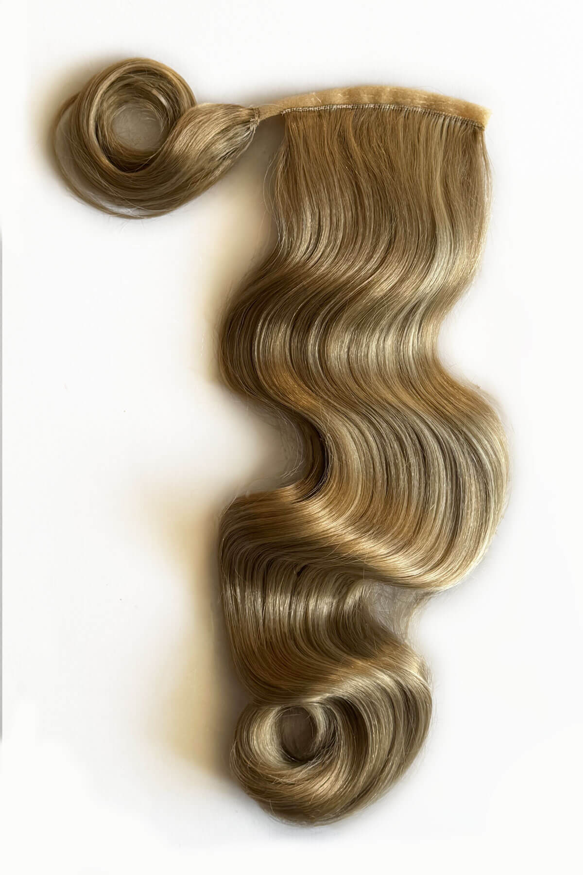 Blonde hair extension with wavy texture on a white background. Long ponytail hairpiece with vintage waves: Kitrysha - blonde 24H613