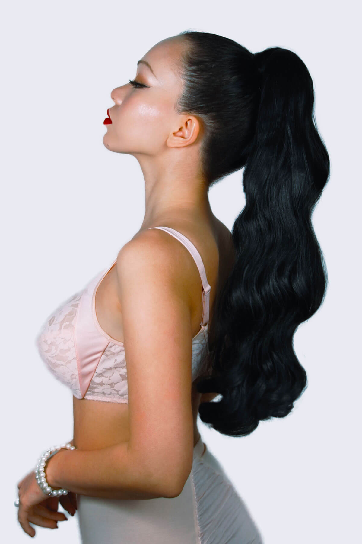 Woman with long black hair styled in a high ponytail against a white background. Long ponytail with vintage waves: Kitrysha black 1b