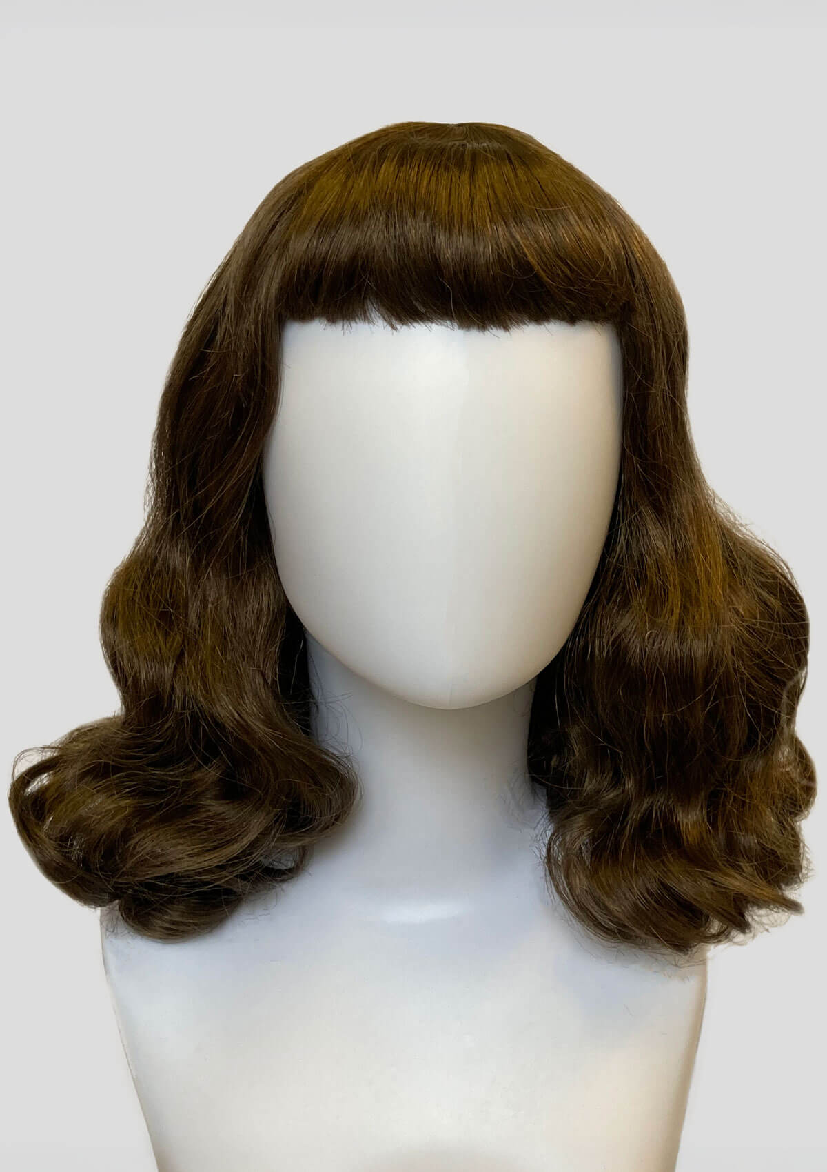 Brown wig with bangs on a mannequin head against a white background. Medium brown pinup style wig, curled with short fringe: Carolina brown 10