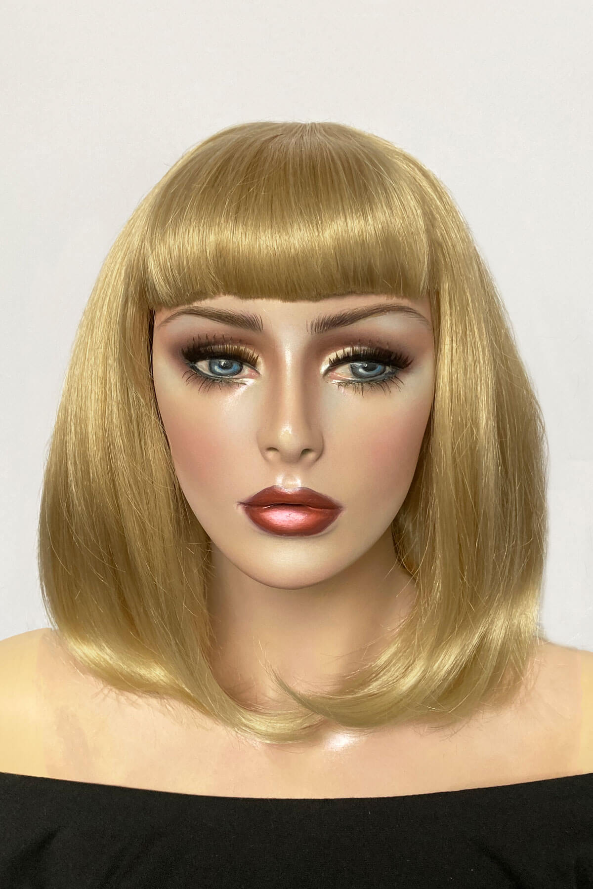 Mannequin head with a blonde bob wig on a white background. Blonde long bob wig with short fringe: Gloria