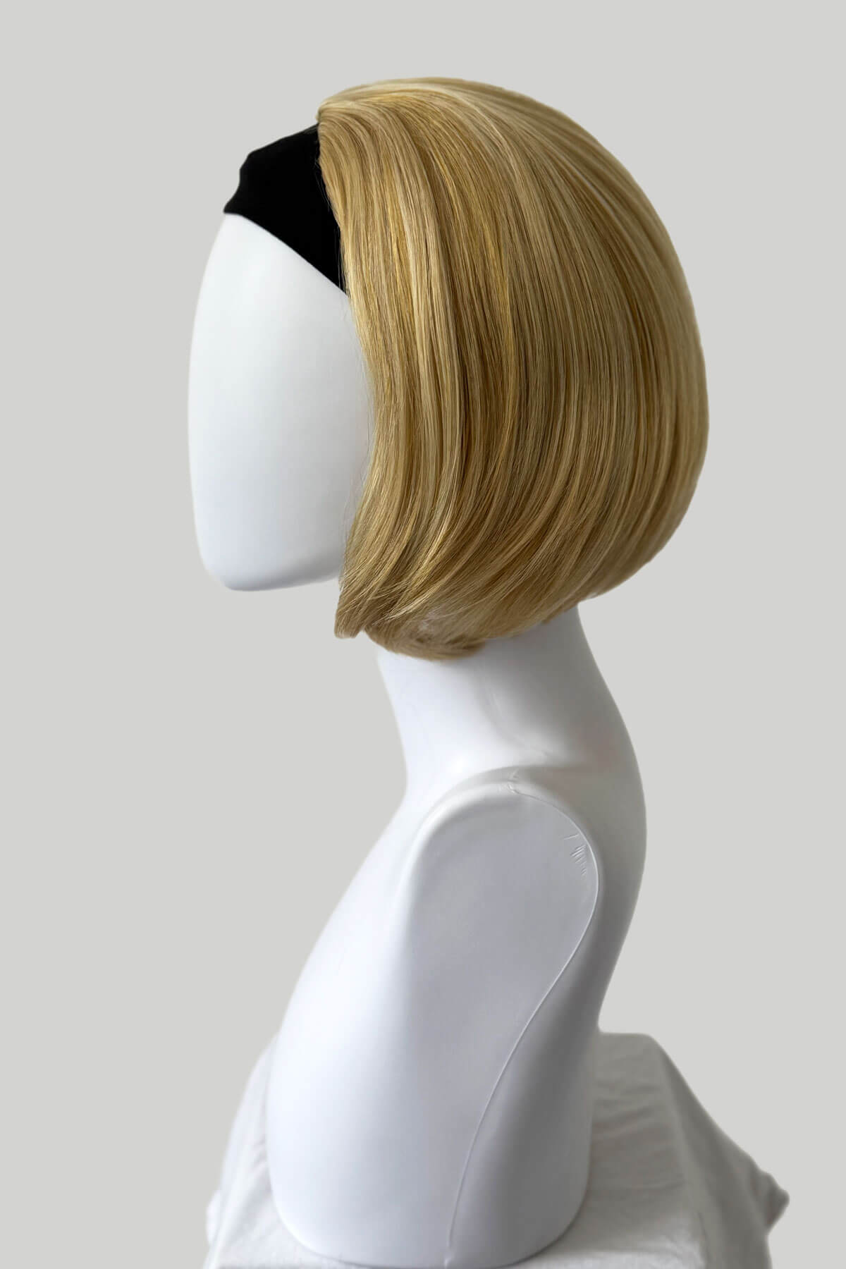Blonde wig on a mannequin head against a plain background. Bob half wig hairpiece, Flexihair: Amelie honey blonde 24BH613