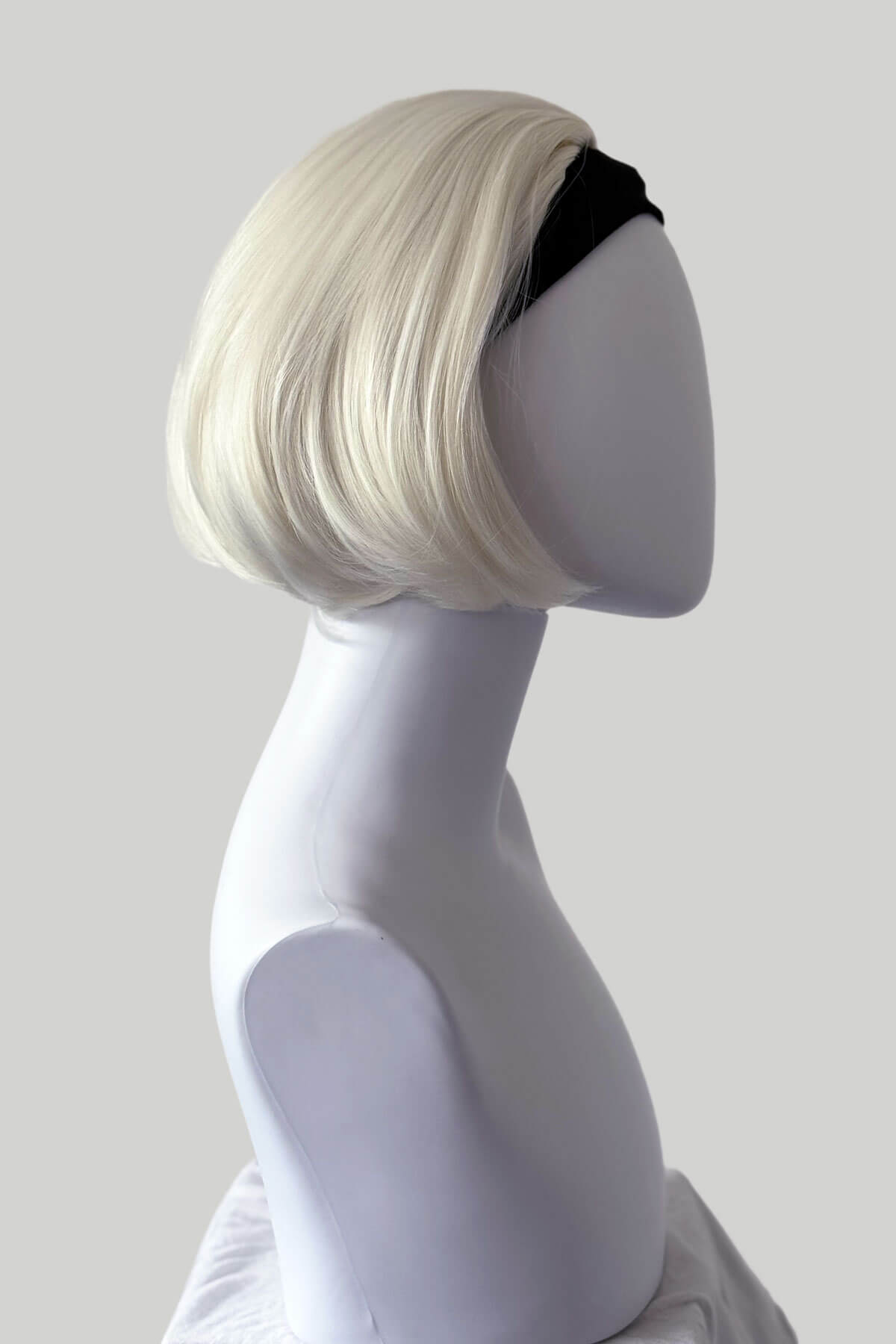 Mannequin head with a blonde wig on a plain background. Bob half wig hairpiece, heat styleable: Amelie platinum blonde 1001