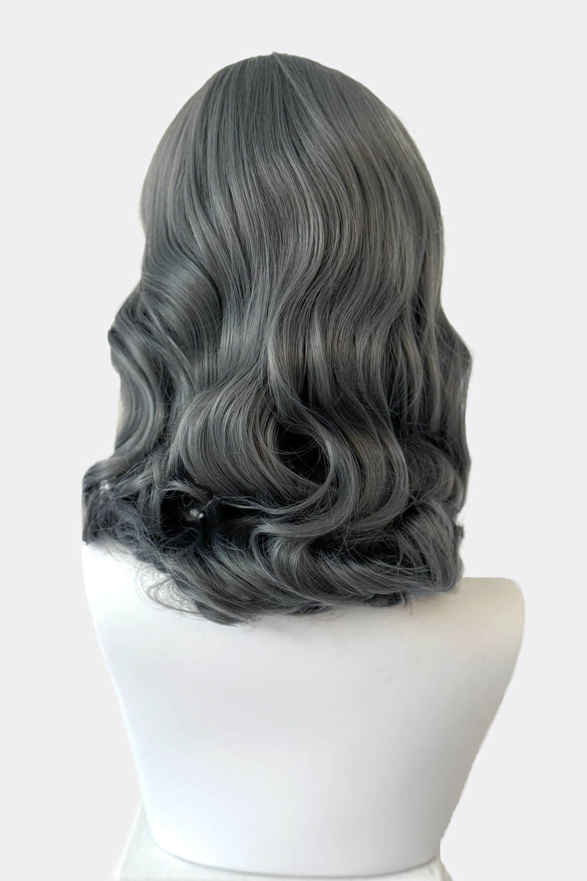 Gray wig on a mannequin head against a white background. Silver-grey pinup style wig with long waves and short fringe, 1950s style: Dotty