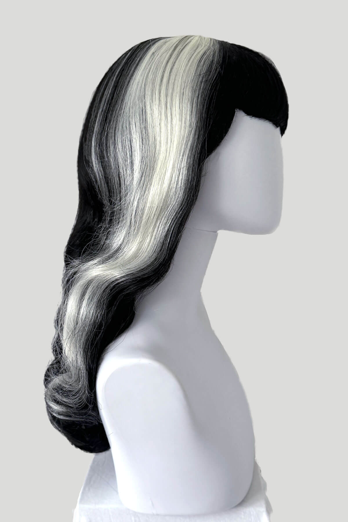 Mannequin head with black and gray ombre wig on a plain background. Long black 1950s pin up style wig with platinum streak and retro fringe: Michelle