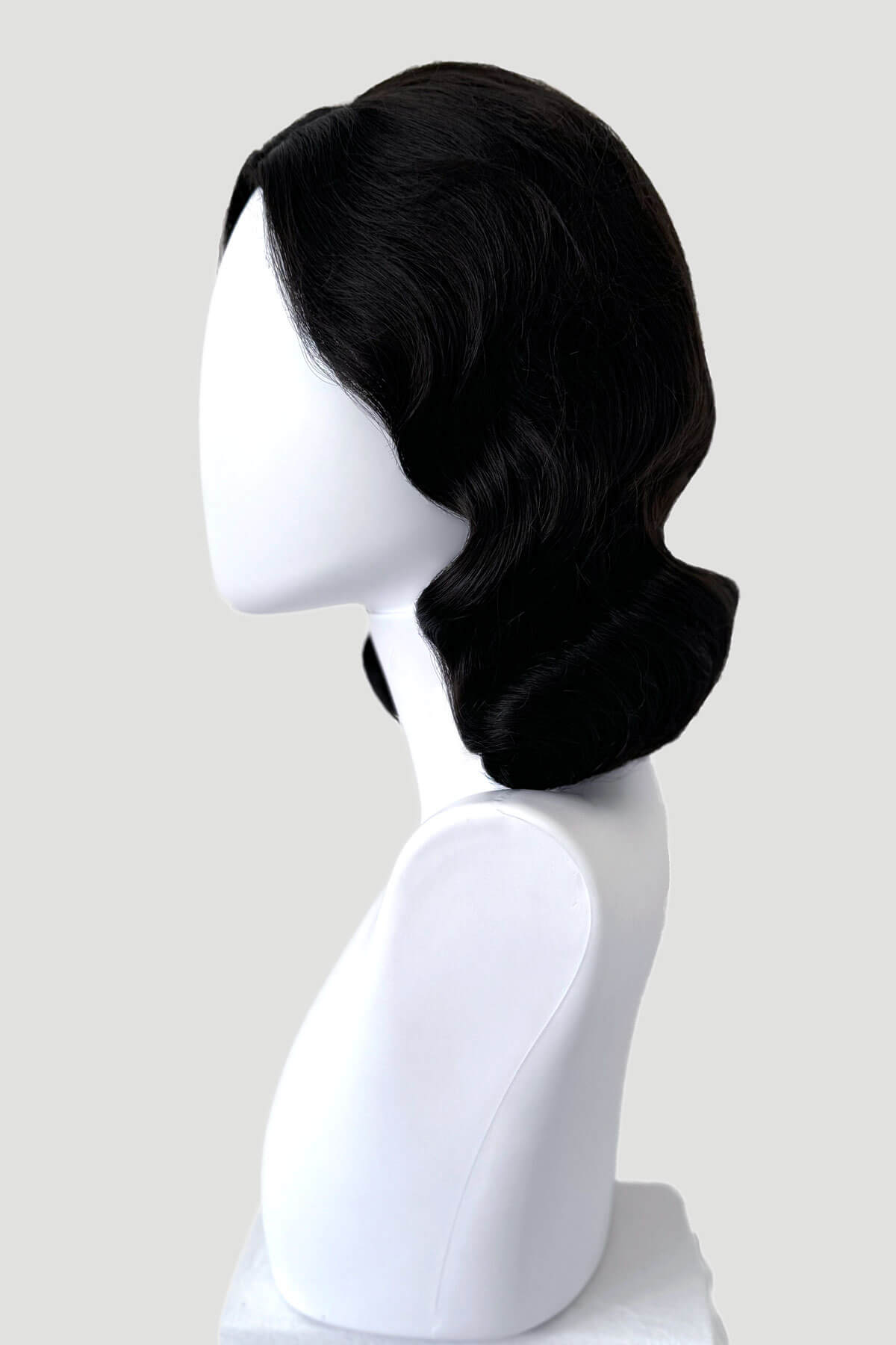 Black wig on a white mannequin head against a light gray background. Brown 1940s pinup style wig, with finger waves: Honey dark brown 4